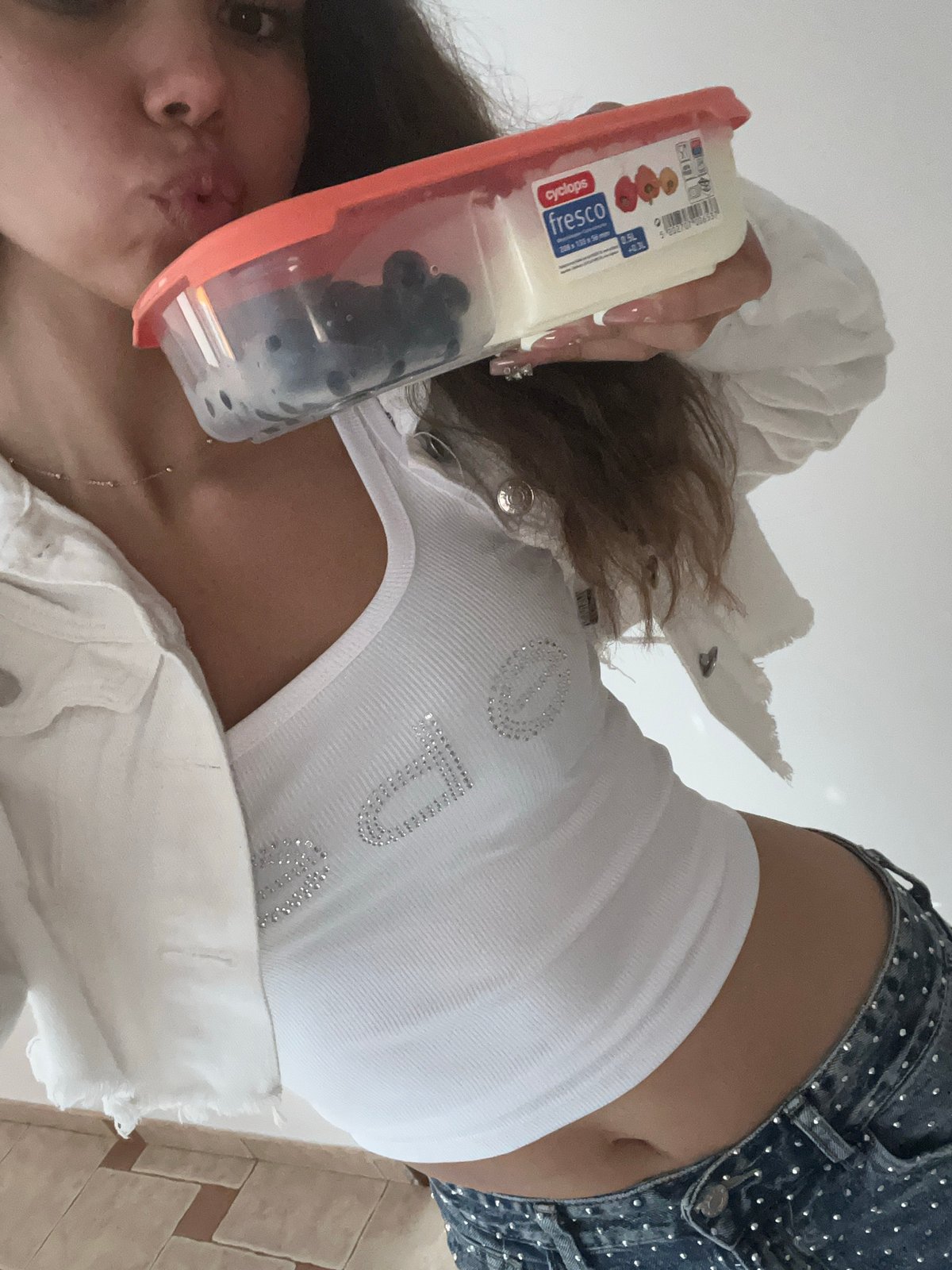 Woman takes multiple indoor selfies with food container
