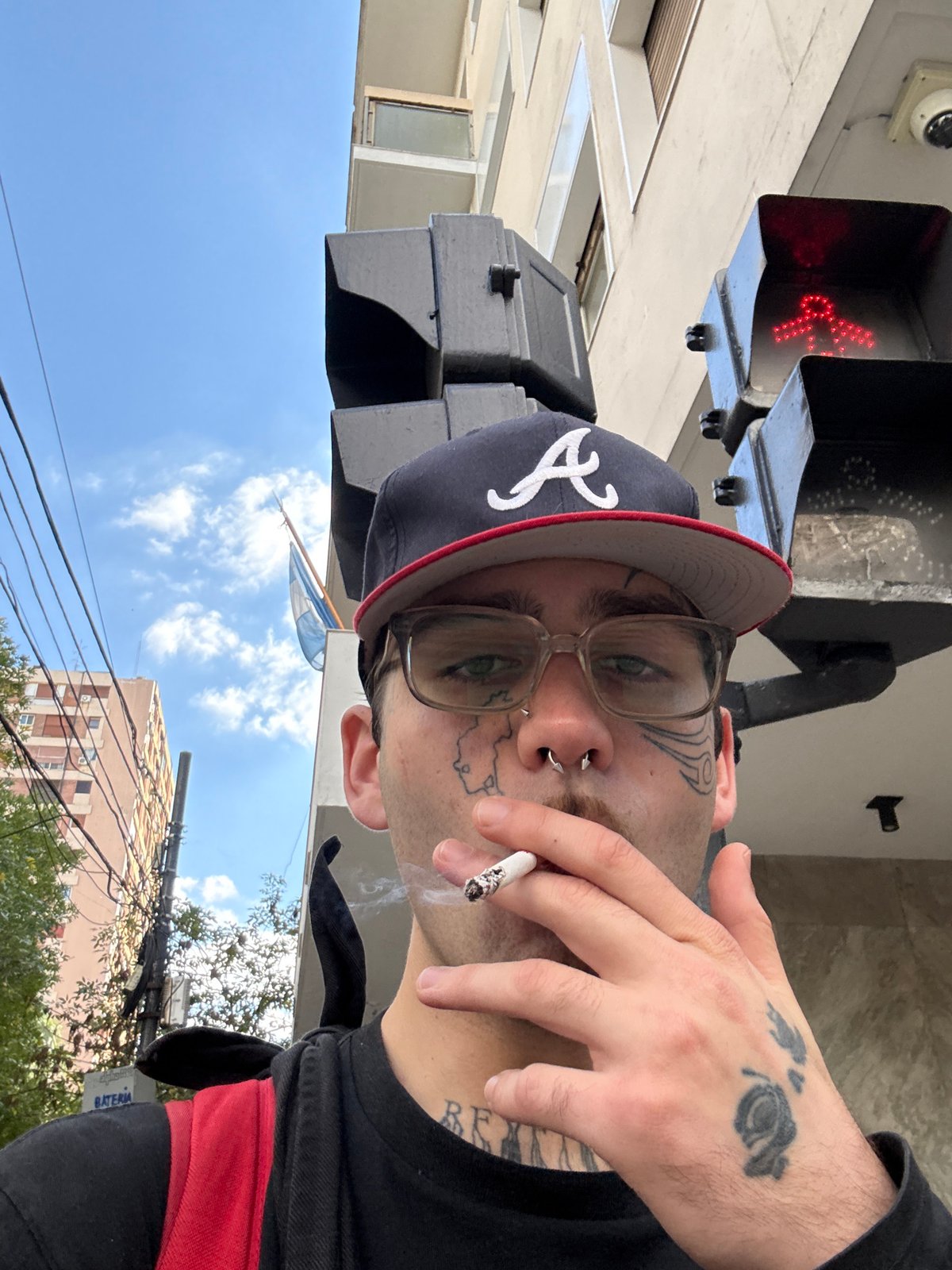 Tattooed individual spotted smoking in Buenos Aires street scene