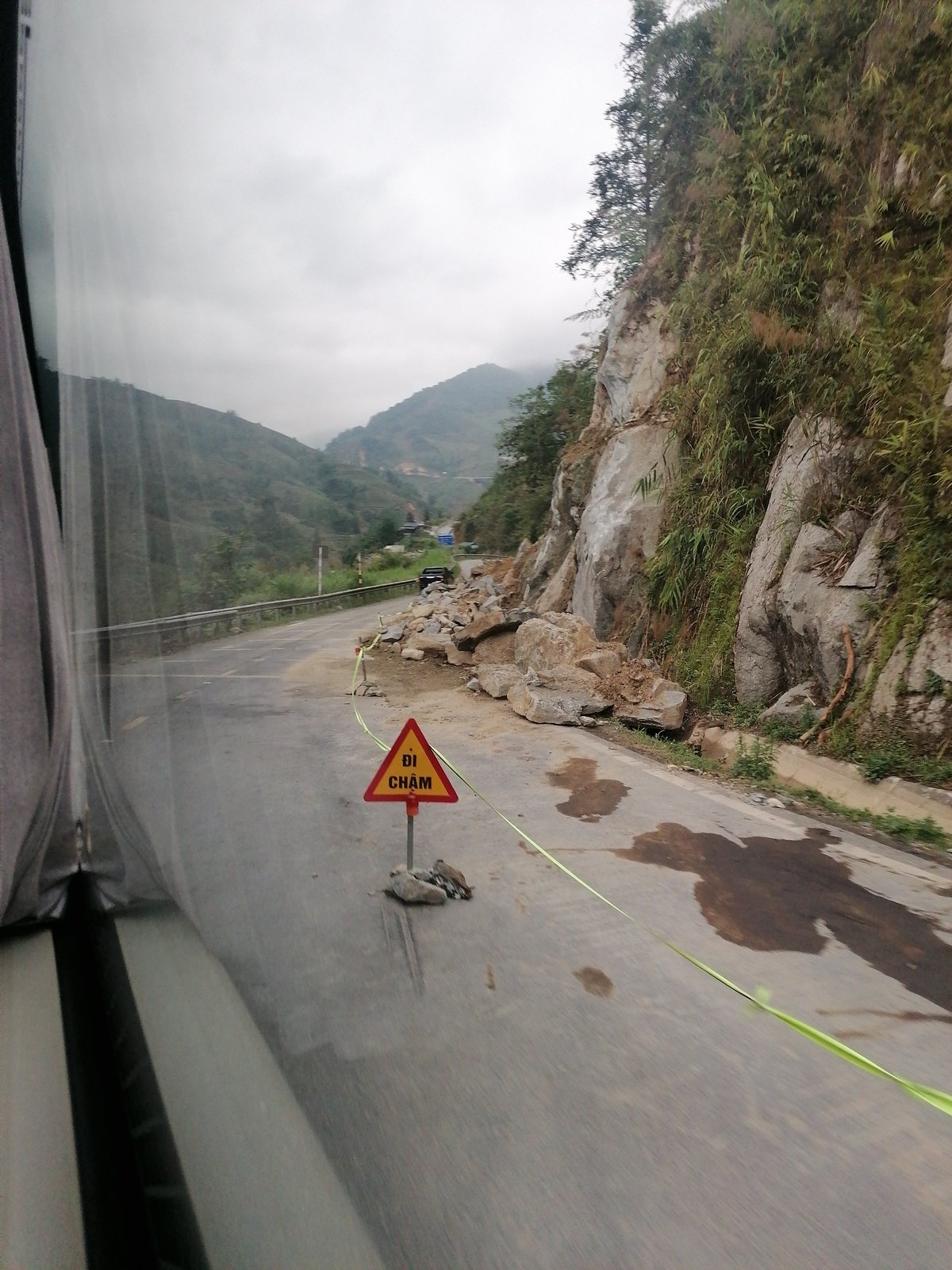 Mountain road partially blocked by rockslide, fog conditions reported
