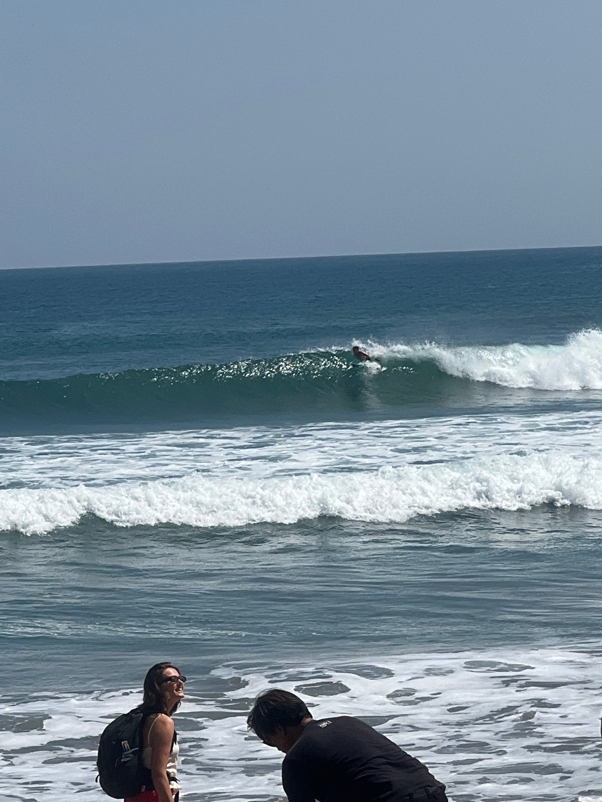 Kuta Beach surf scene with boards, umbrellas, and shoreline activity