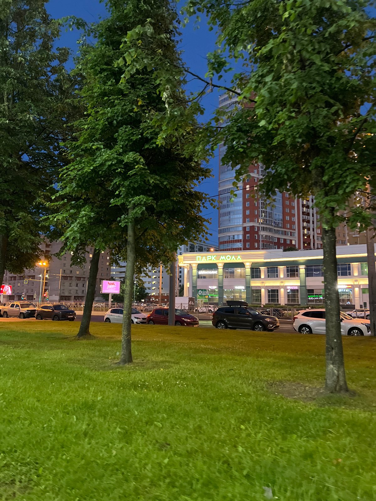 Black Mercedes parked on a city street at dusk