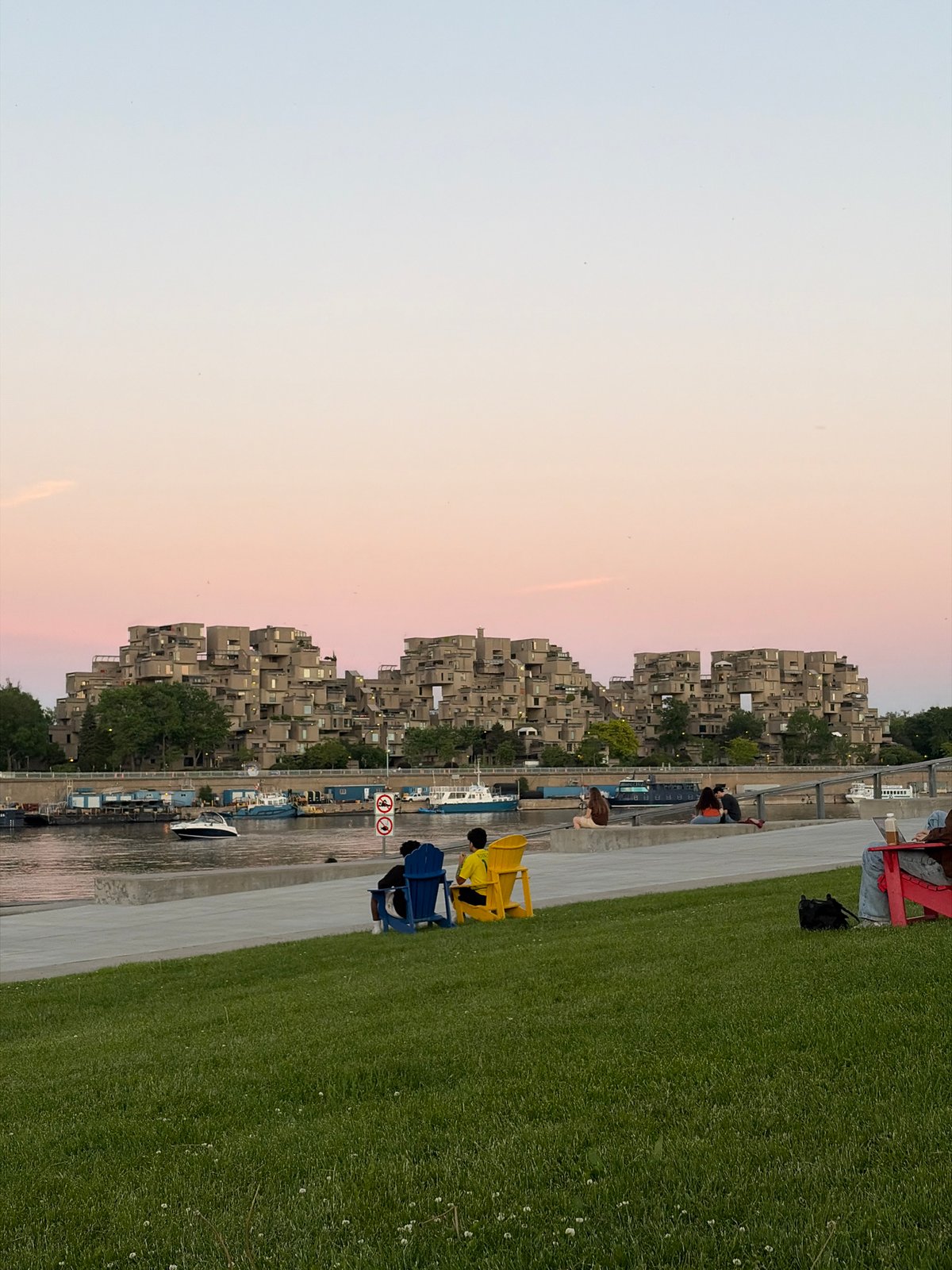 Evening waterfront gathering documented near Montreal's Habitat 67 complex