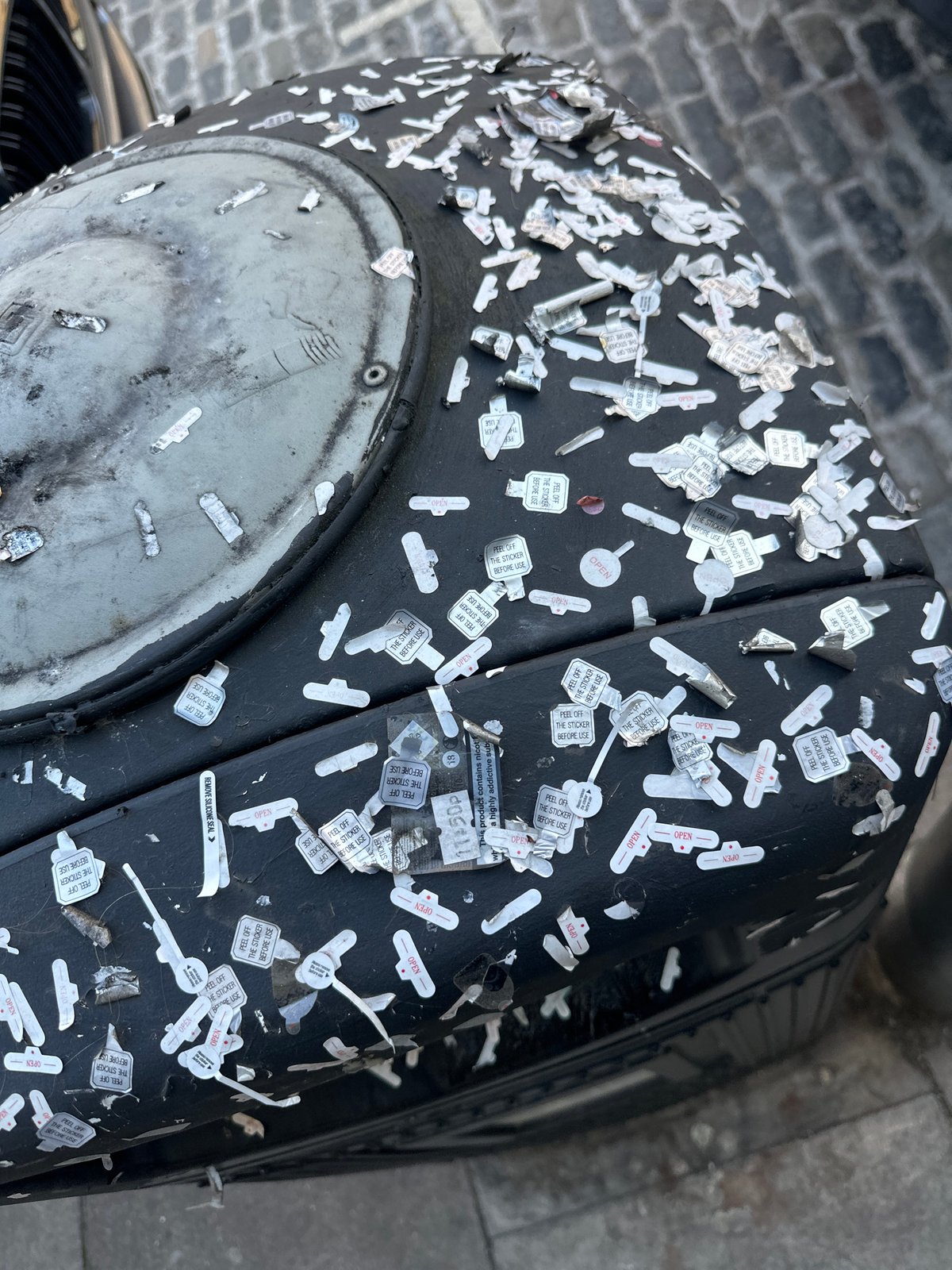Stickered cylindrical object documented on London street