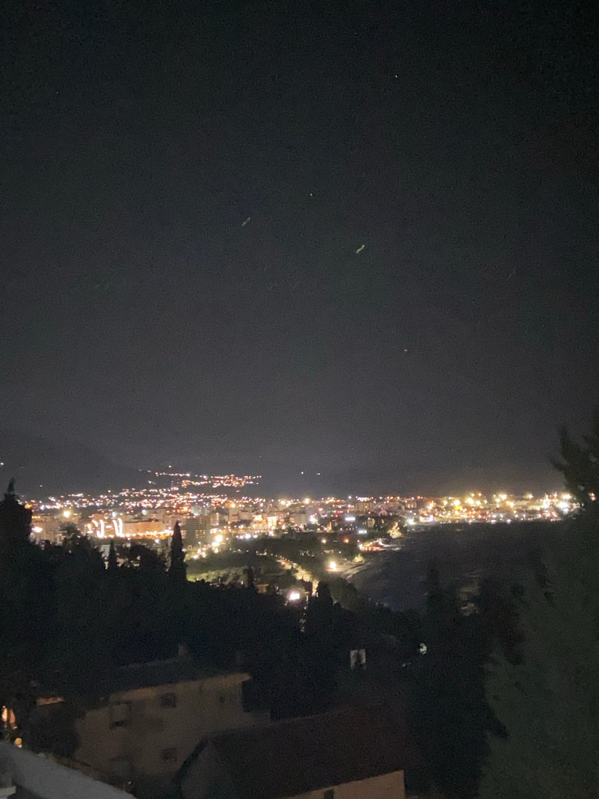 Nighttime coastal lights illuminate Šušanj, Montenegro from above