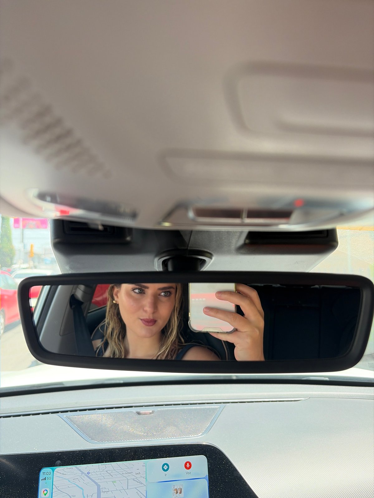 Woman uses smartphone in vehicle in Tlaxcalancingo, Mexico
