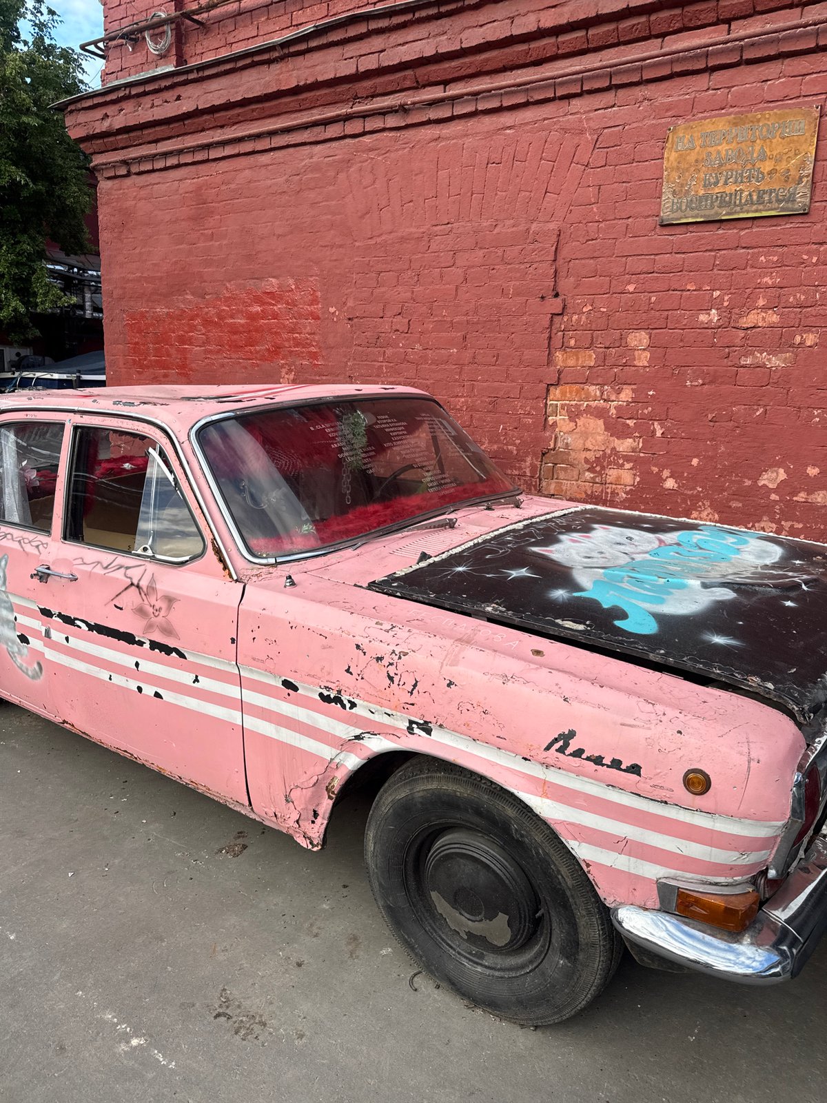 Graffiti-covered brick buildings and vintage cars in Moscow