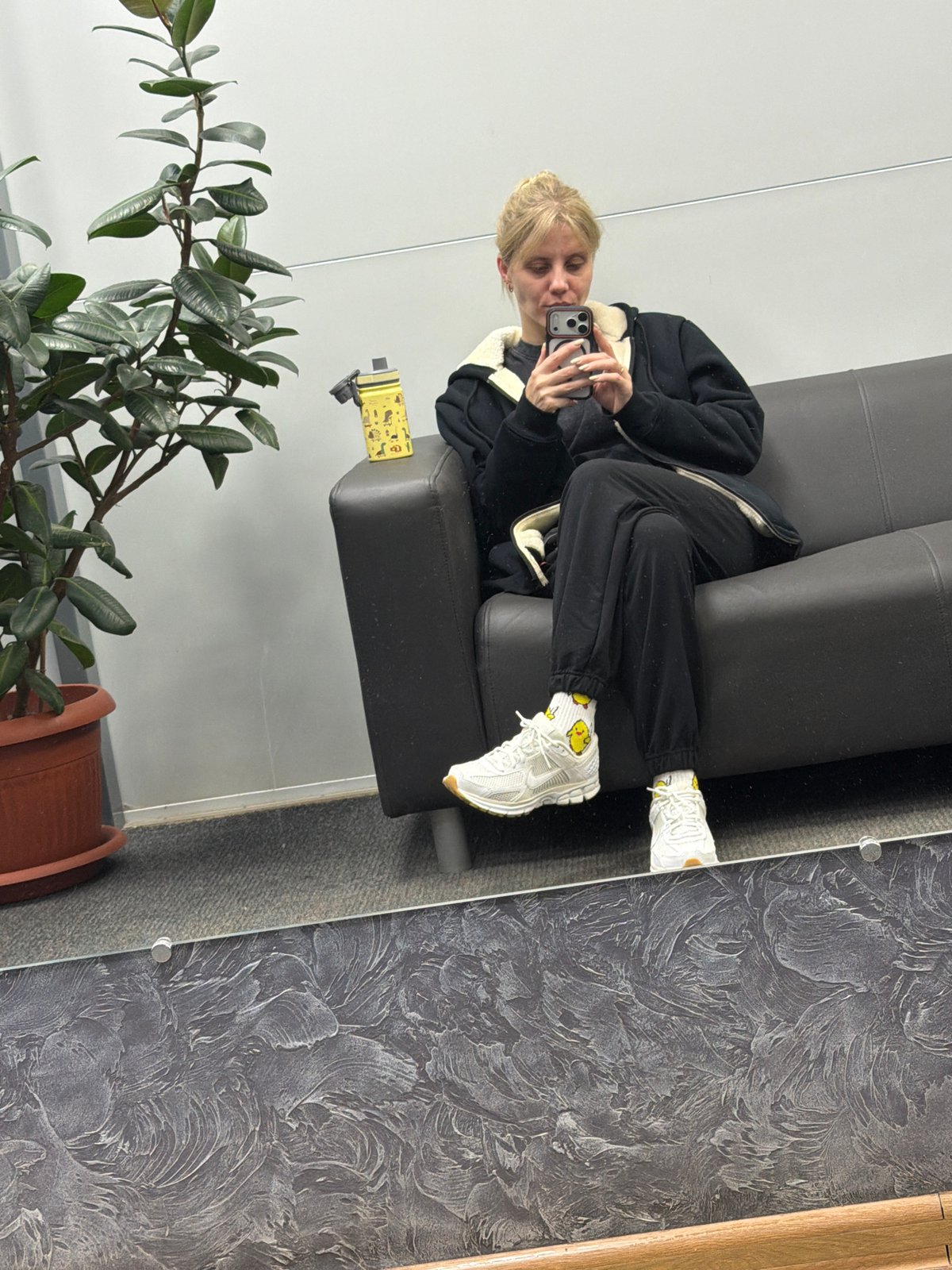 Person photographed using smartphone on couch in Chaikovsky residence
