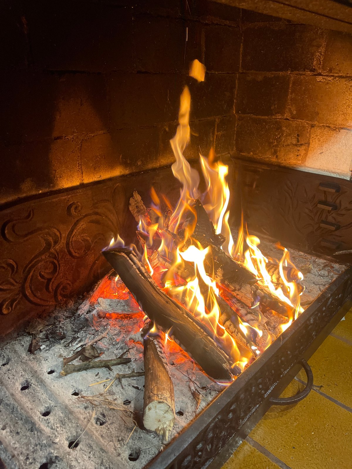 Crackling log fire burning in an outdoor fireplace at night