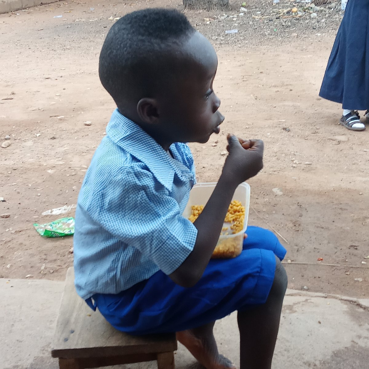 School children eat breakfast outdoors in Akwanga, Nigeria