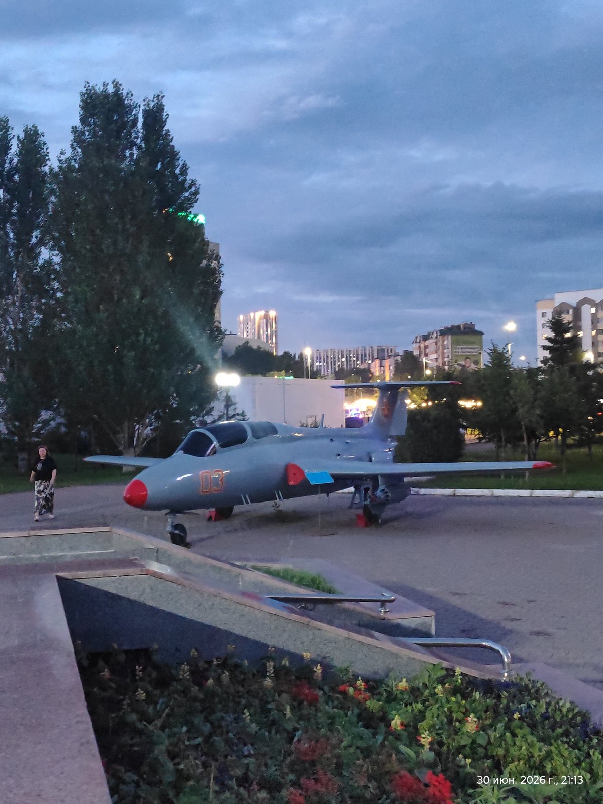 Outdoor military hardware display and city streets at dusk, Astana