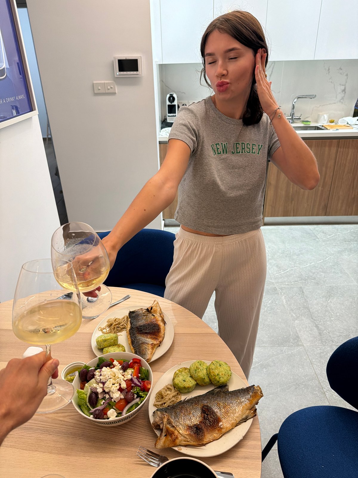 Woman serves wine and fish dinner in Livadia, Cyprus