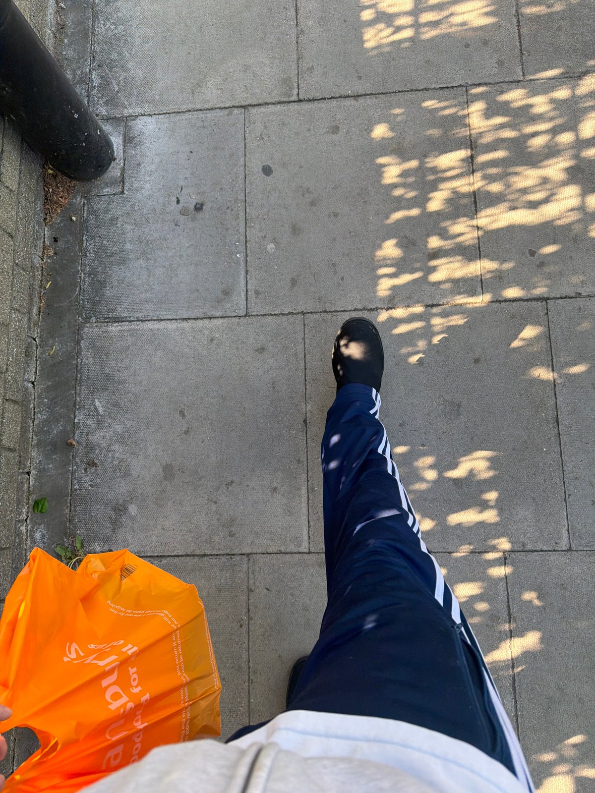 Person photographed on London street during clear spring afternoon