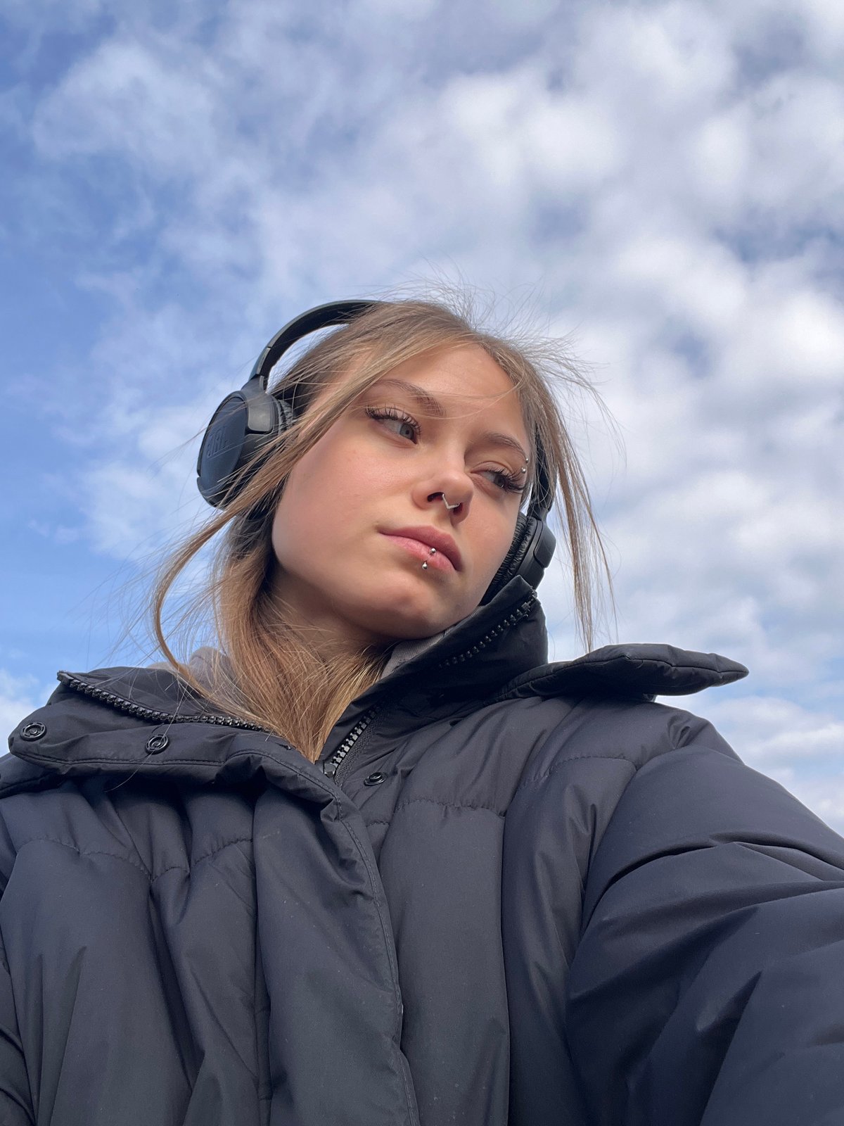 Woman in headphones stands in snowy field, Фоки Russia