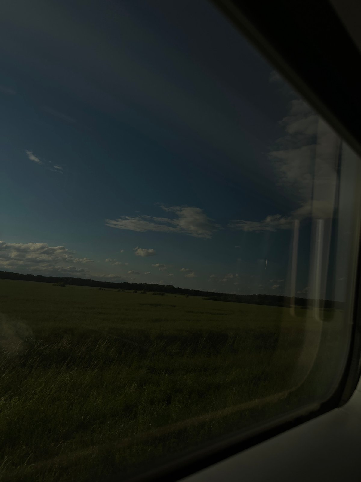 Train passenger documents rural German countryside during evening journey