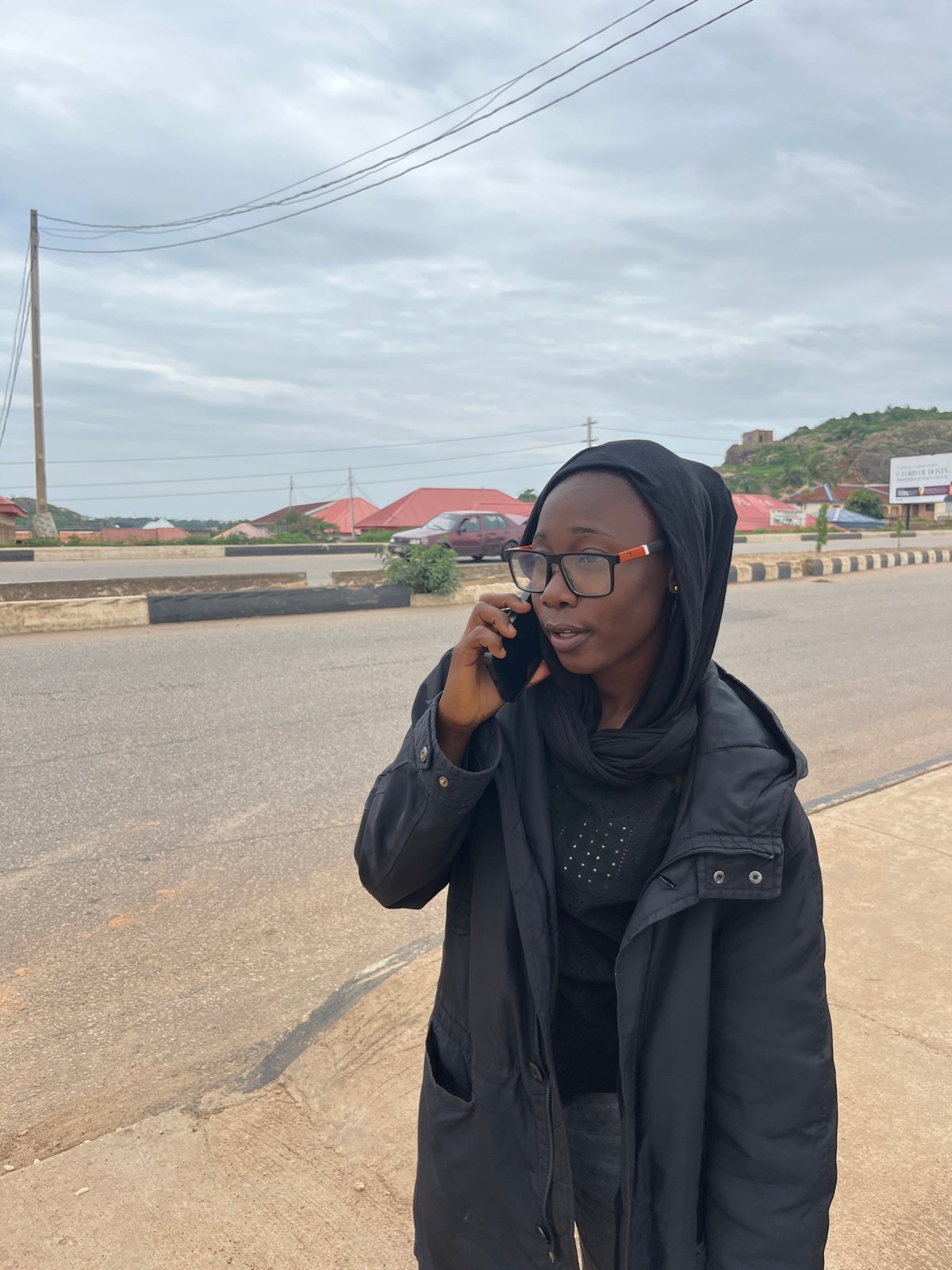 Afternoon street scene in Gura Top, Nigeria with cake and a phone call