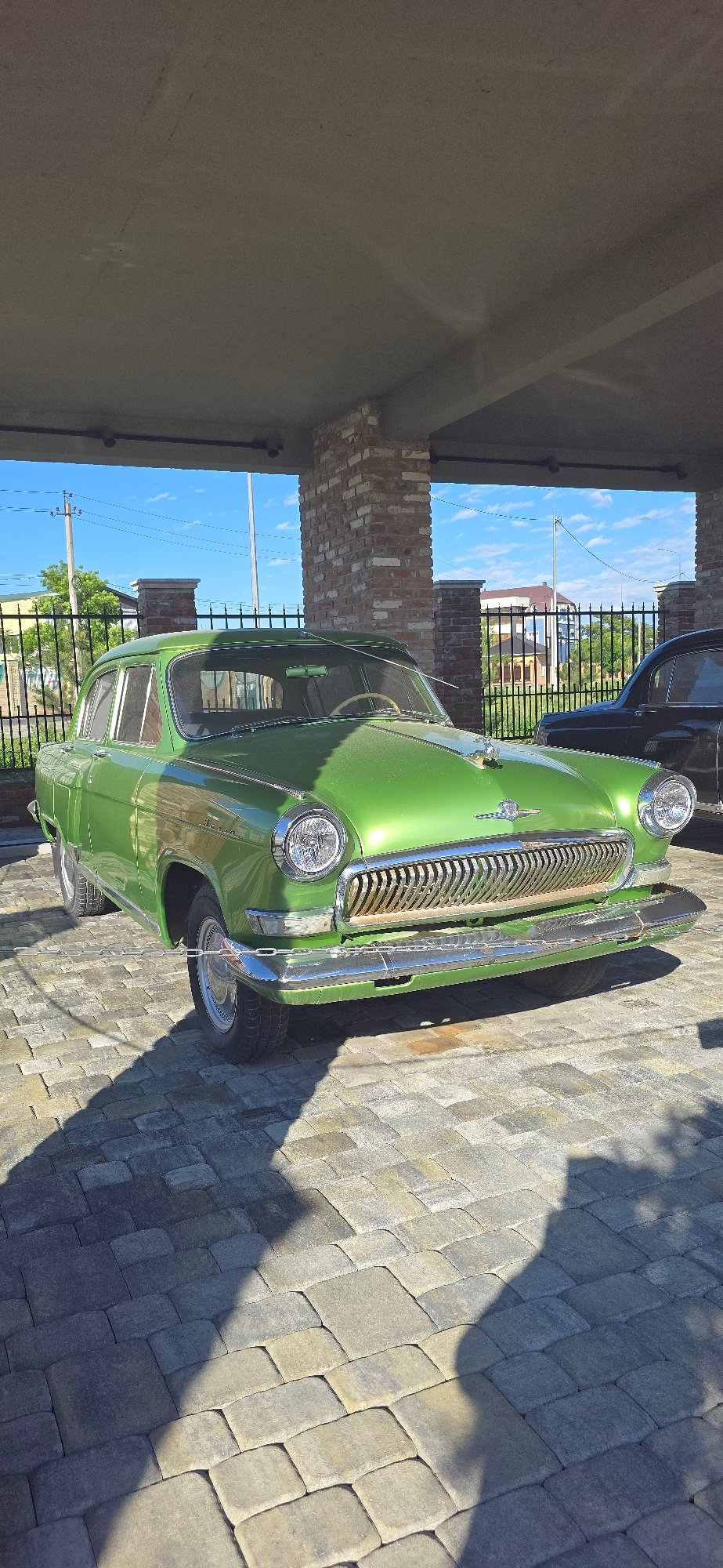 Classic car gathering observed near deteriorating brick building