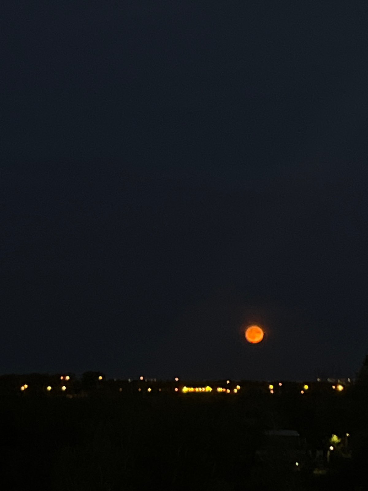 Orange moon rises over Samara as the Volga catches a summer sunset