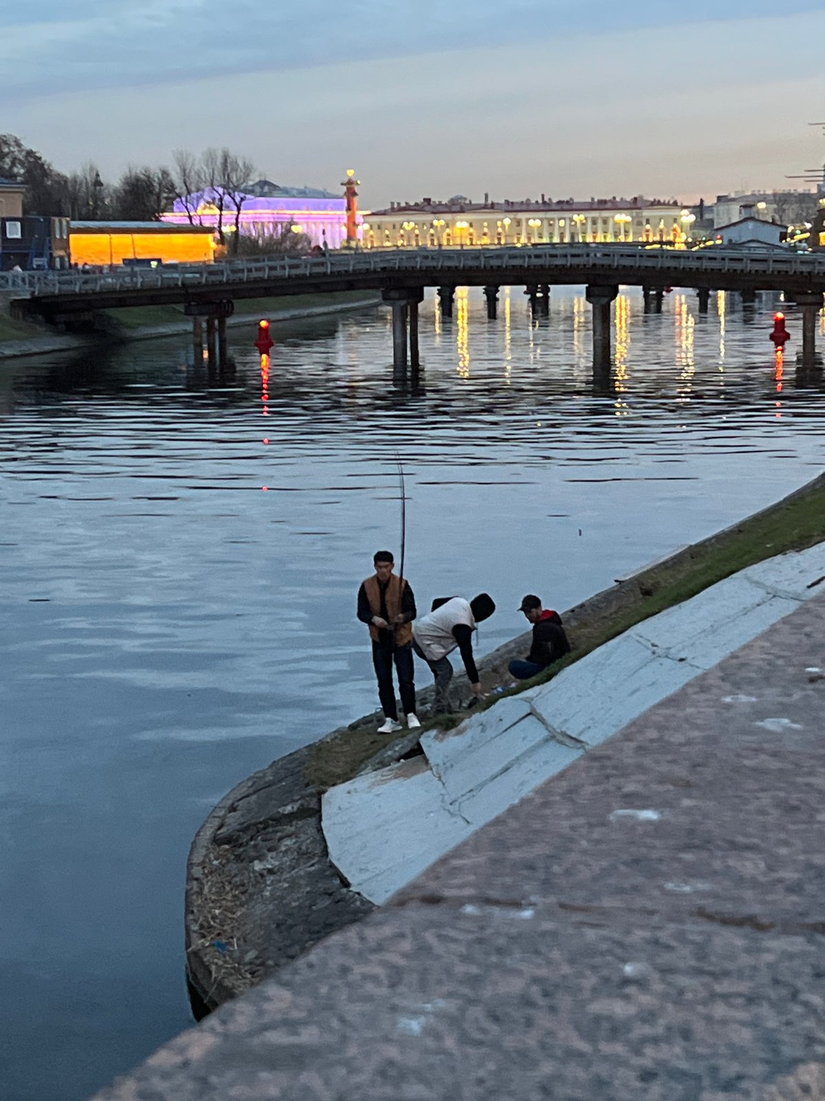 Evening fishing scene captured along Saint Petersburg waterfront at dusk