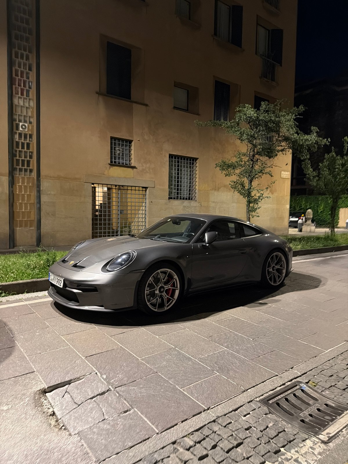 Evening dining documented at Milan restaurant, sports car nearby