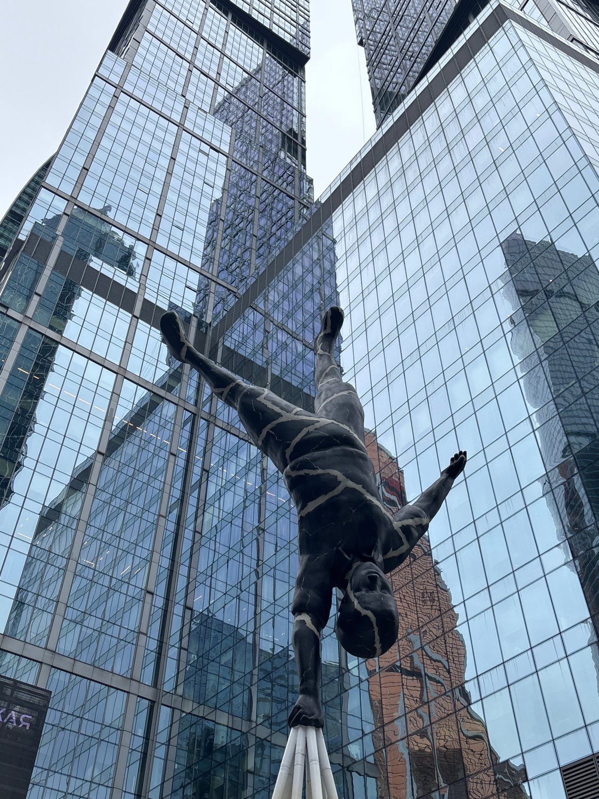 Woman visits Moscow City business district amid sculptures, building maintenance
