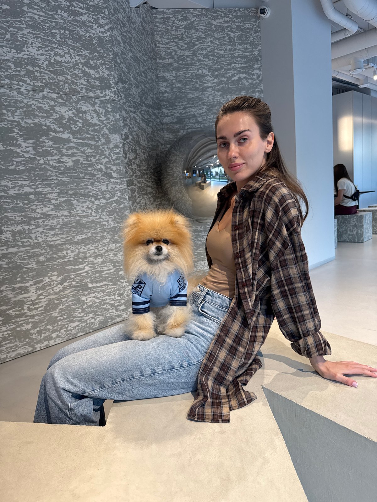 Woman with Pomeranian dog photographed during casual afternoon outing