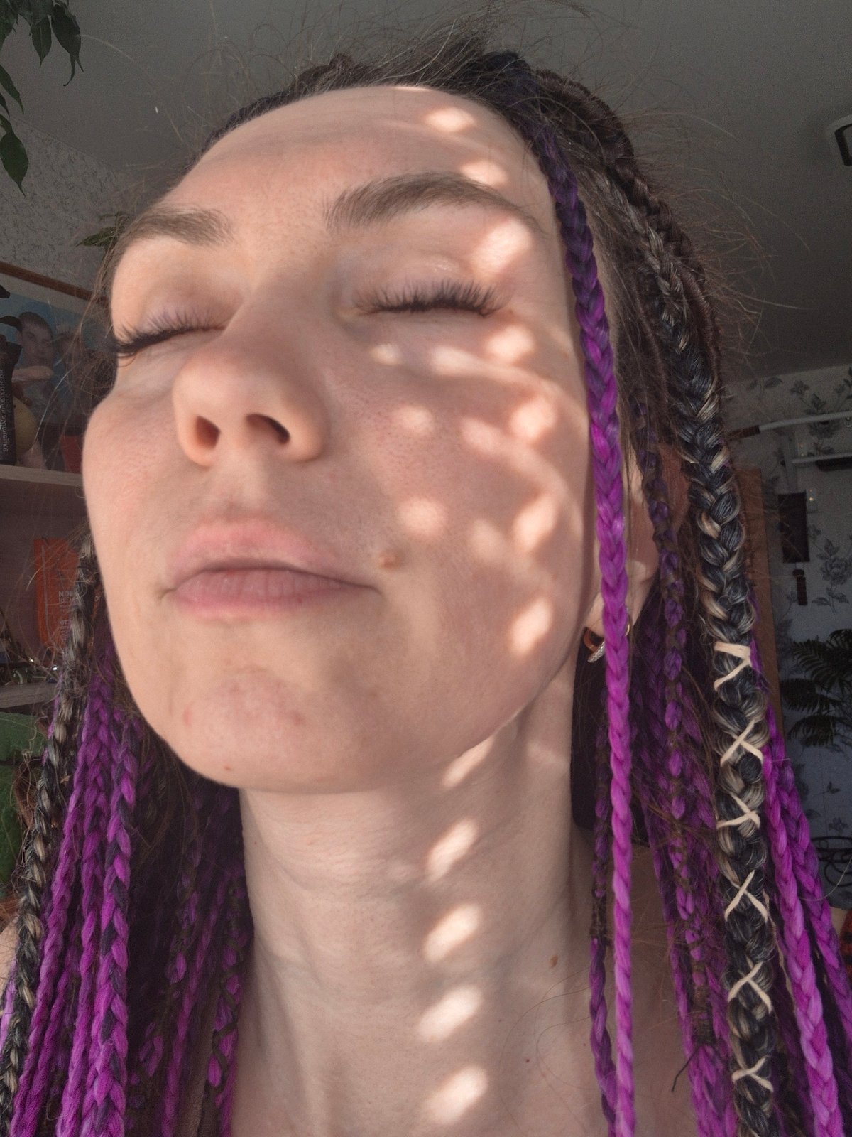 Person rests in dappled sunlight, eyes closed