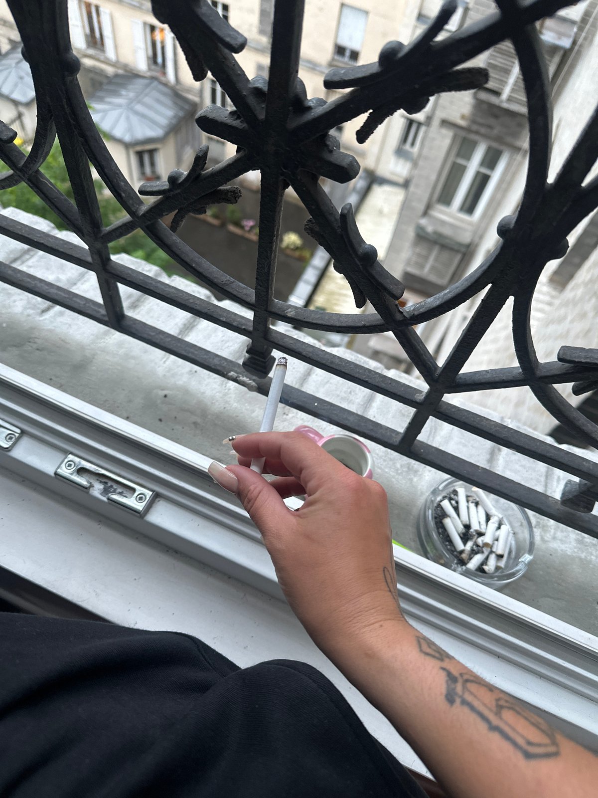 Person smoking on apartment balcony in Saint-Ouen-sur-Seine