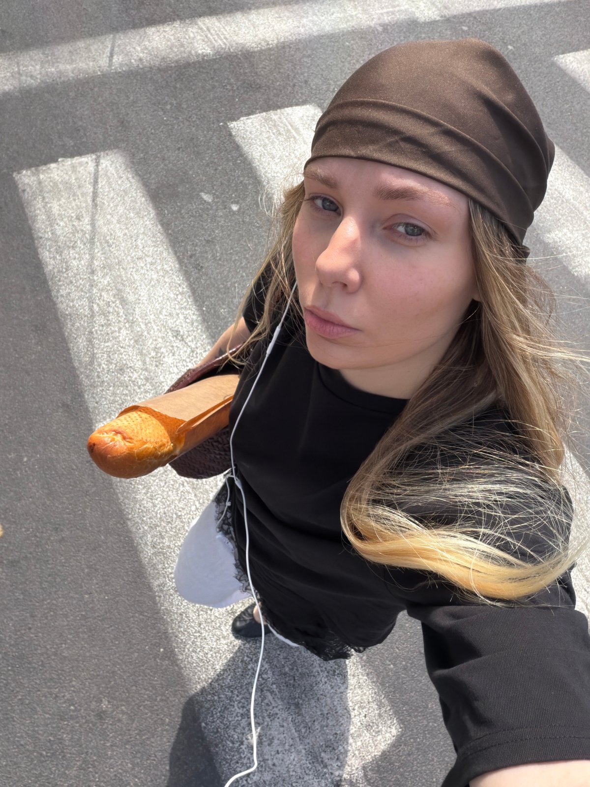 Woman with baguette crosses Tel Aviv street Monday morning