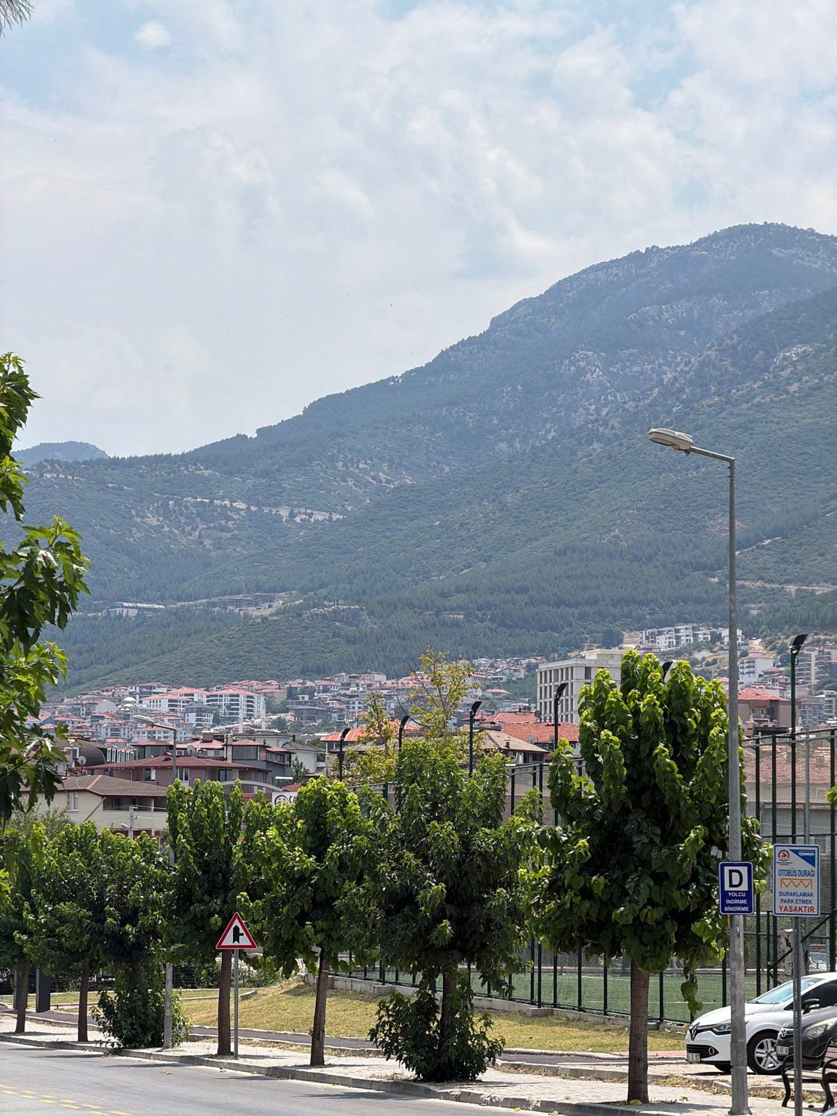 Street-level look at a Denizli neighborhood with municipal and commercial signage
