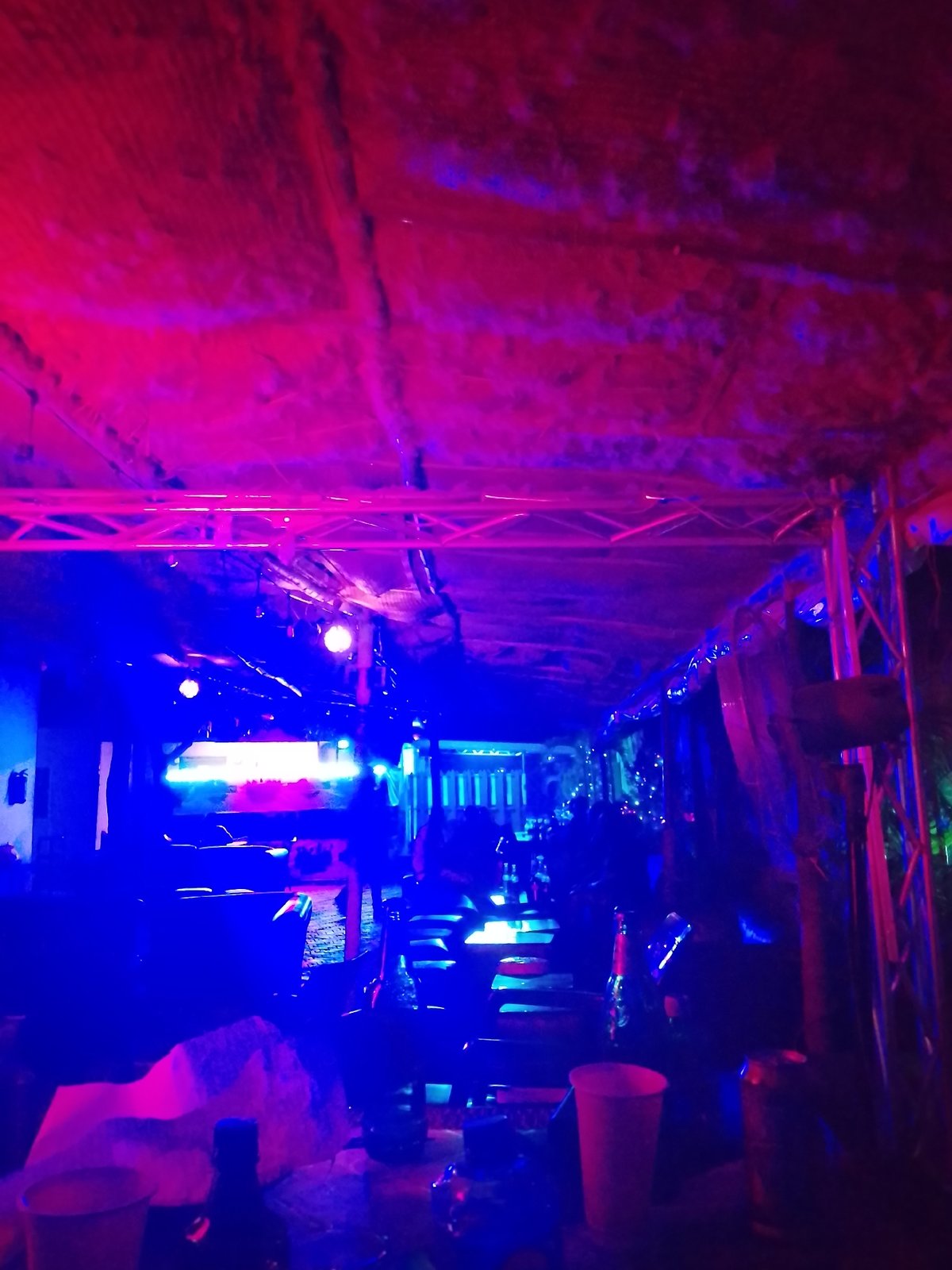 Neon-lit nighttime social gathering documented in Yelwa, Nigeria venue