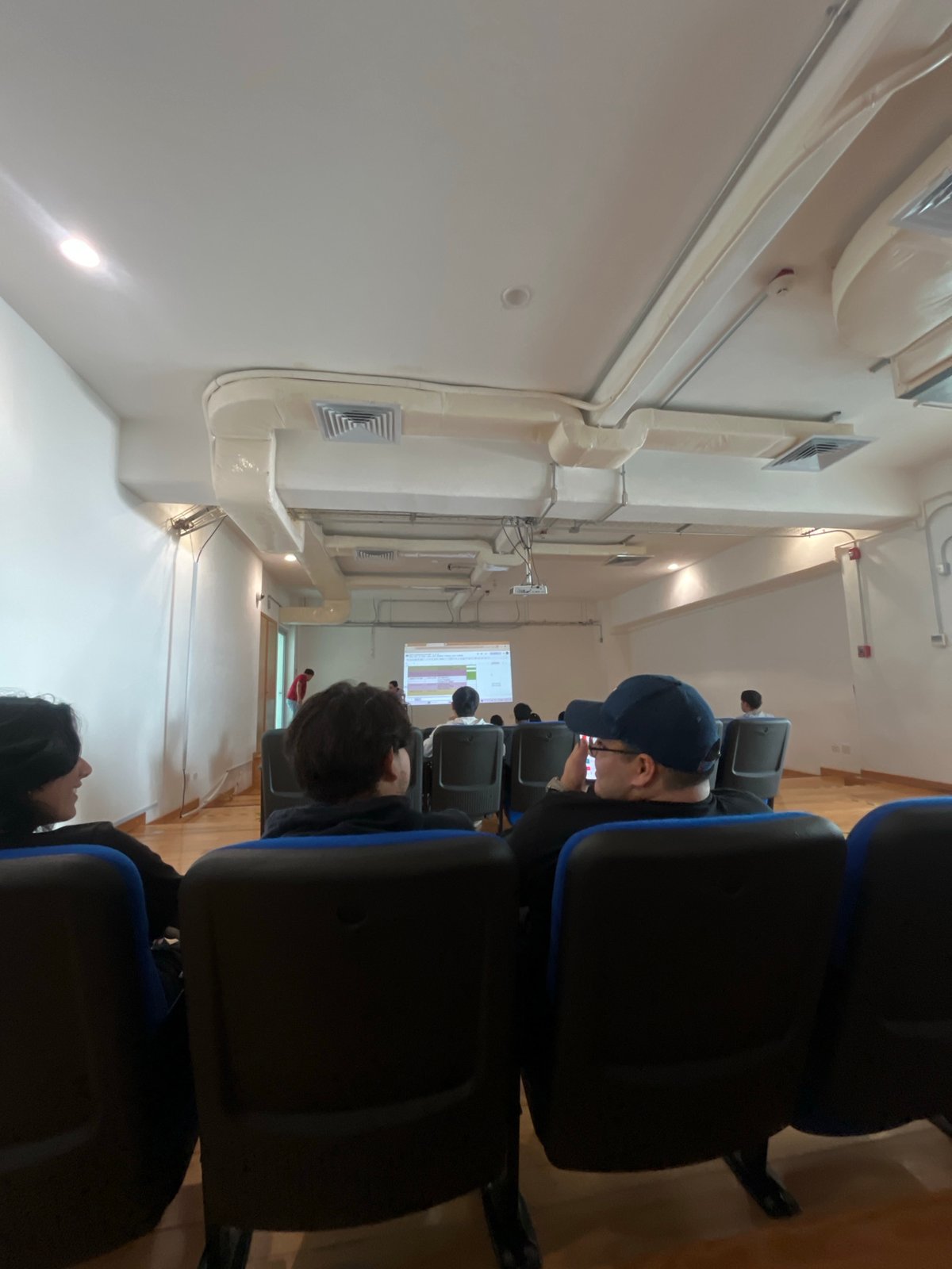 Classroom presentation observed with attendees facing projection screen
