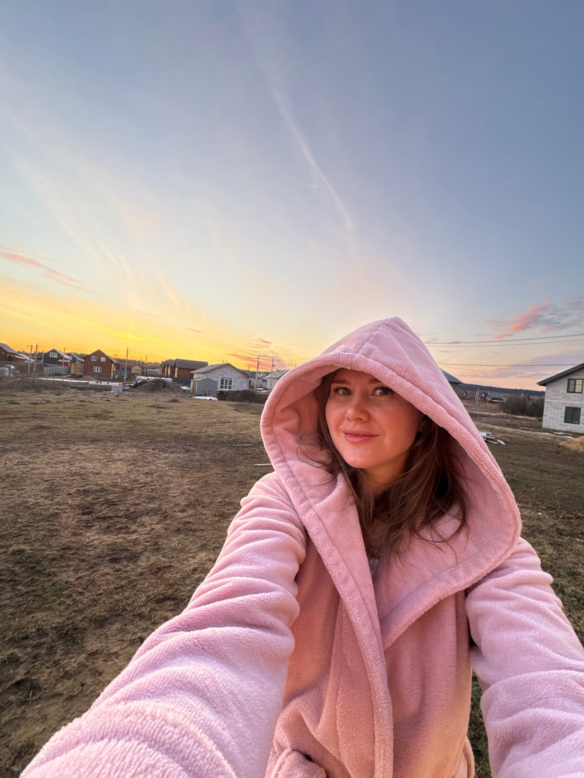 Woman takes selfie at dawn in Russian village