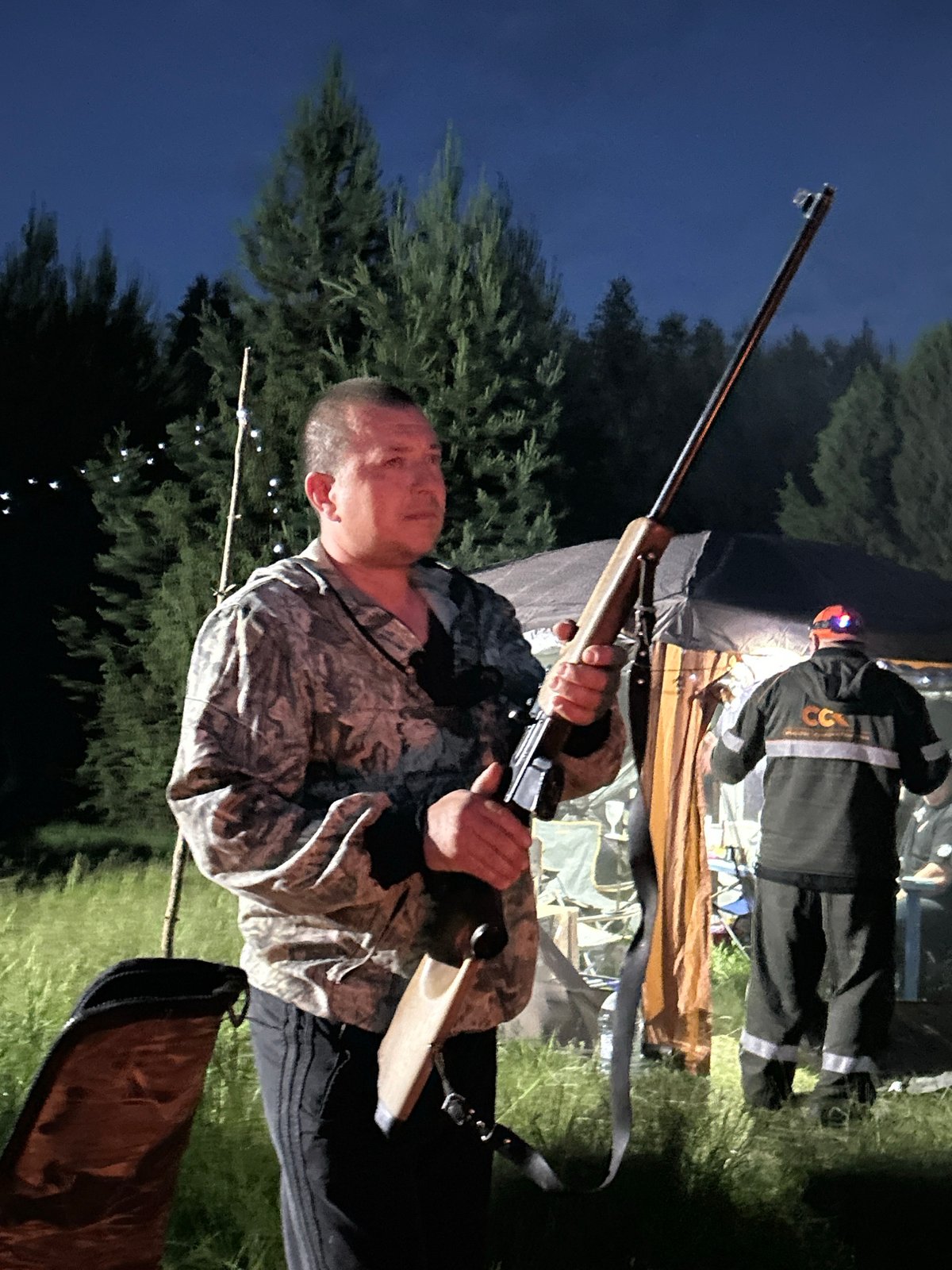 Camping group enjoys sunset activities by lake in Plishkino