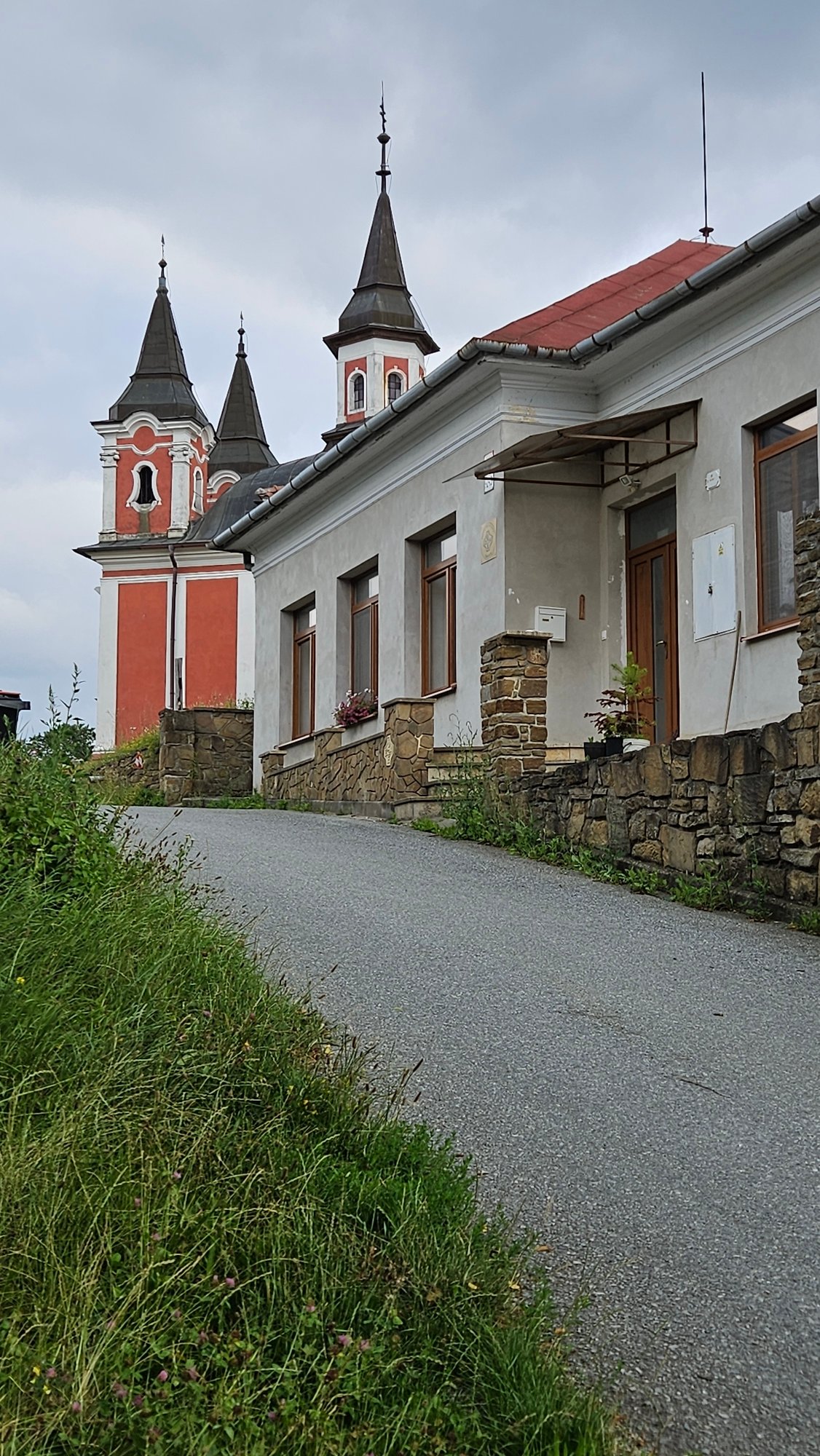 Hiking a wooded hillside in Prešov with flowers and city views