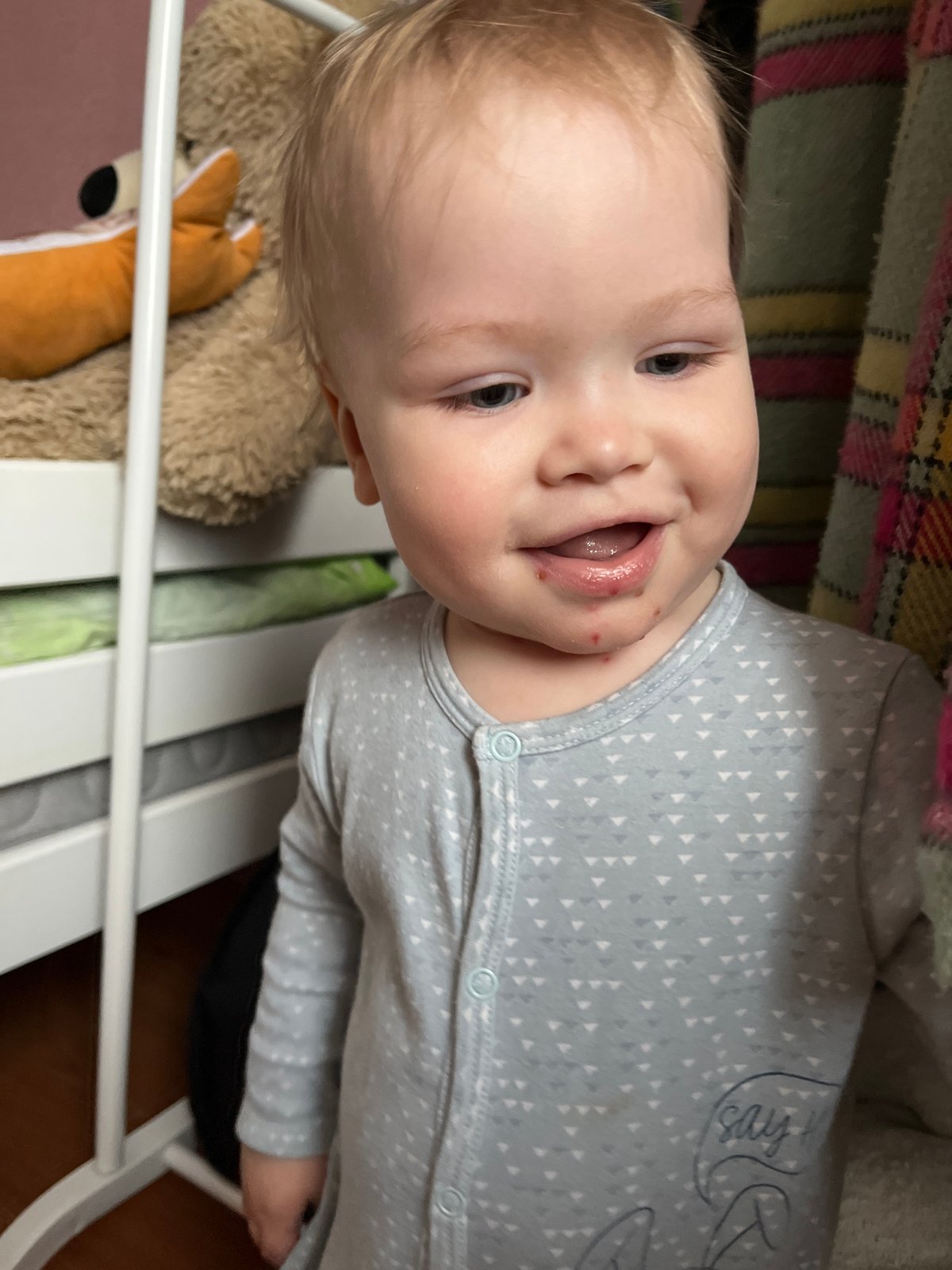 Baby plays with doll while cat poses near window