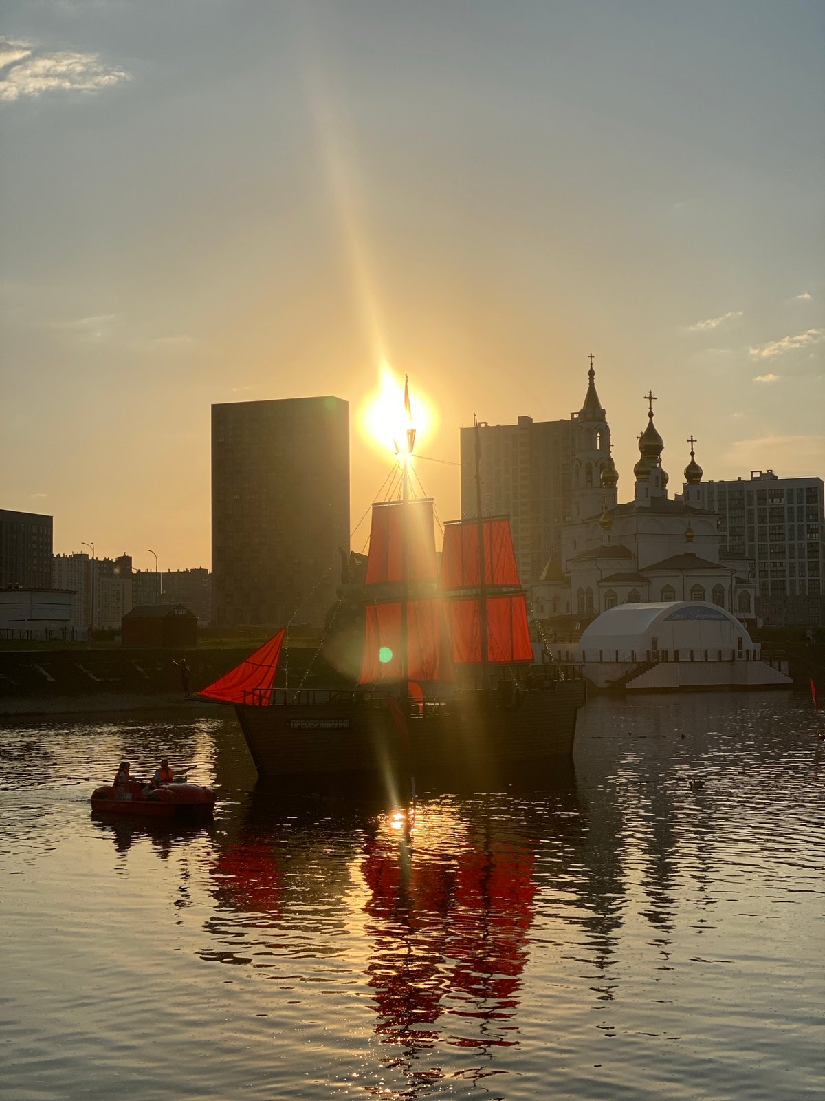 Red-sailed ship captures attention during Yekaterinburg waterfront sunset