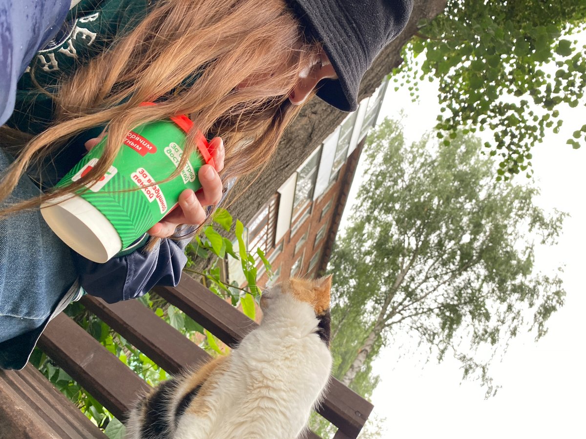 Calico cat hangs out with its owner in Votkinsk park