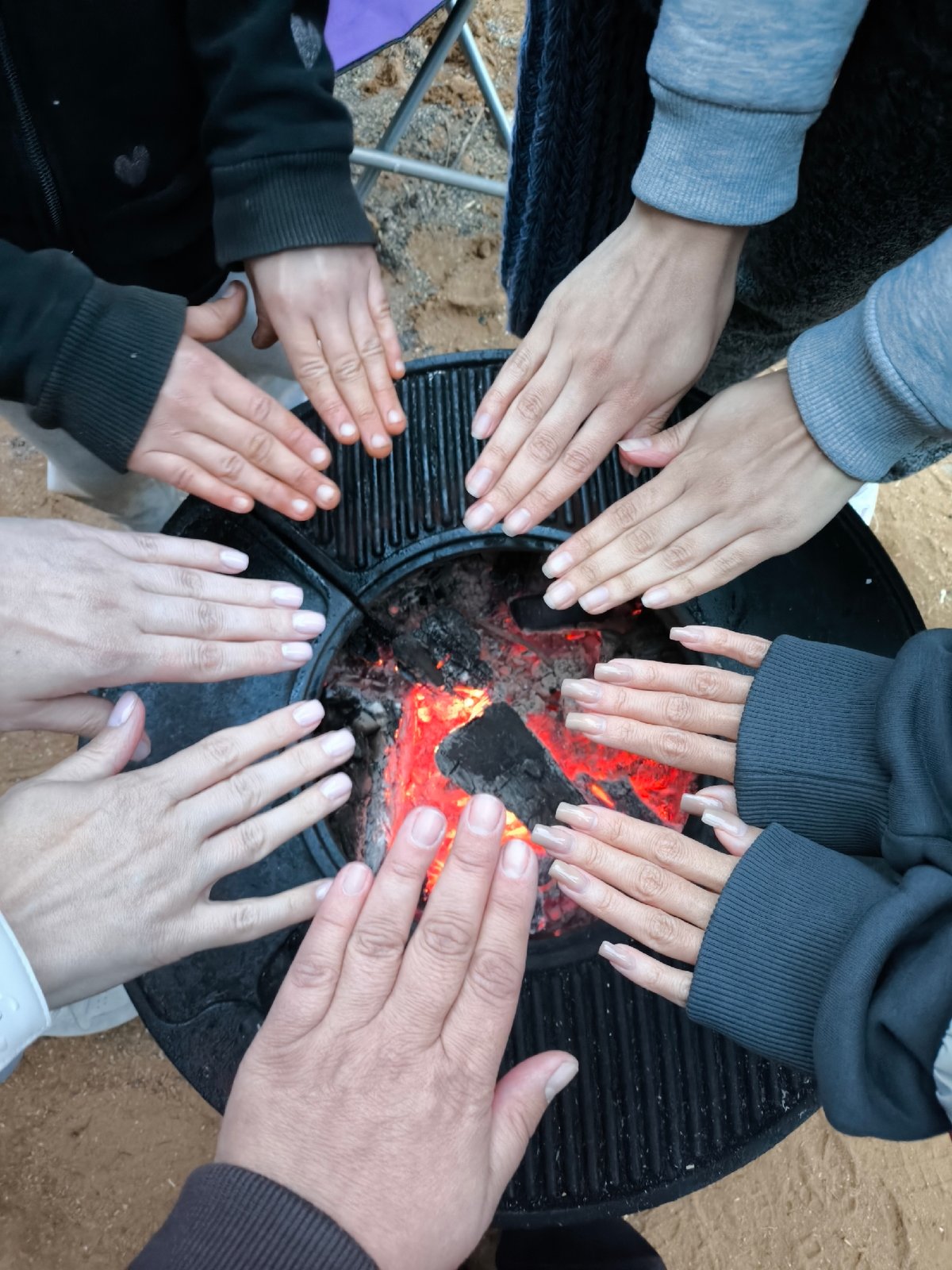 Family gathering around fire pit during evening hours