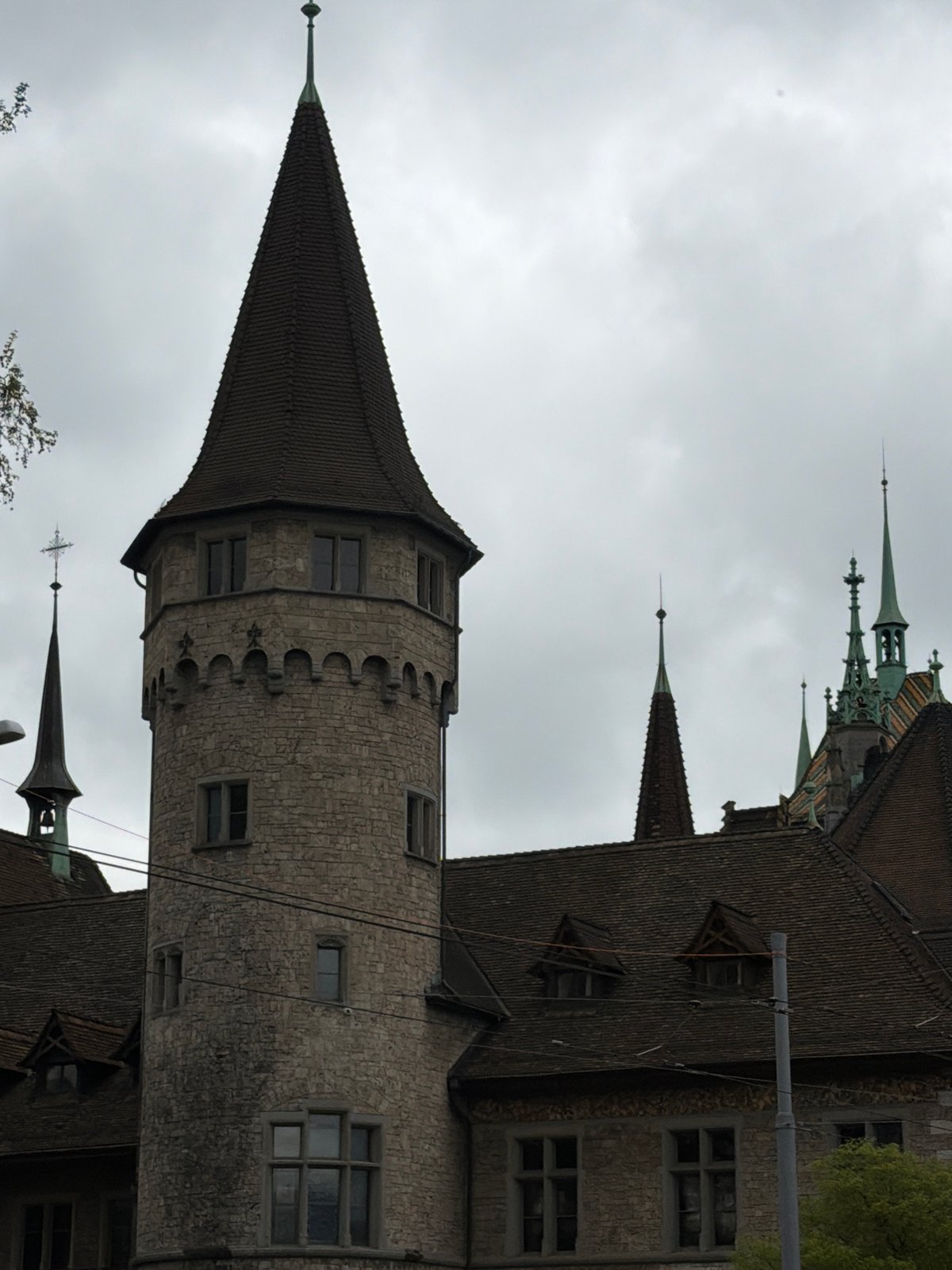 Tourist photographs Zurich's historic Swiss National Museum and Rathaus
