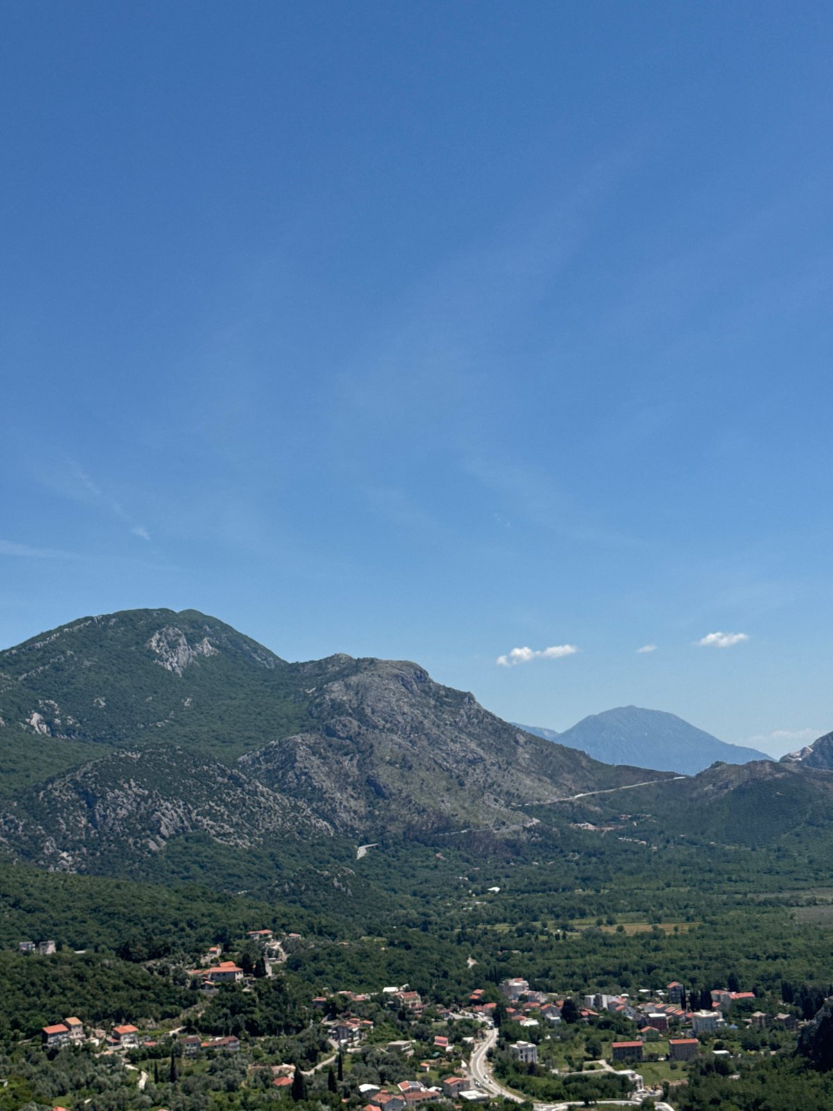 Tourist documents scenic coastal views in Montenegro resort town