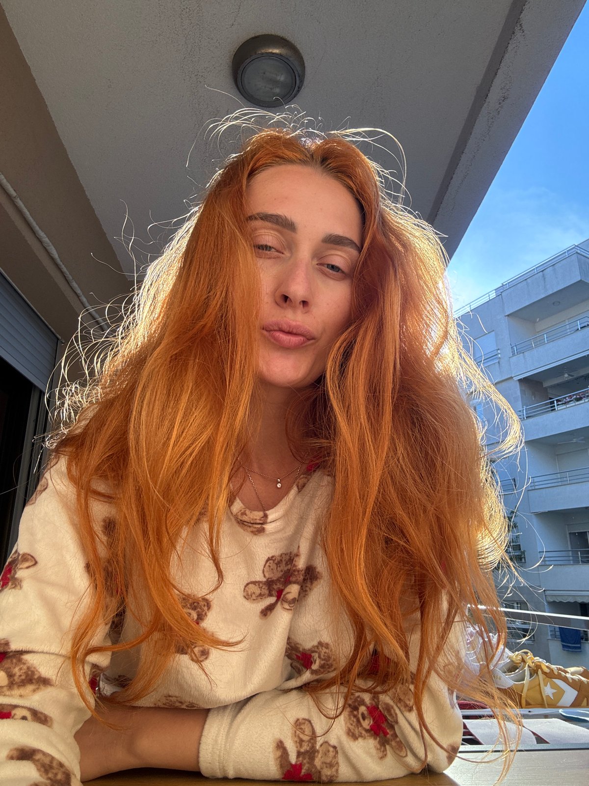 Woman spends quiet afternoon on Budva balcony in pajamas
