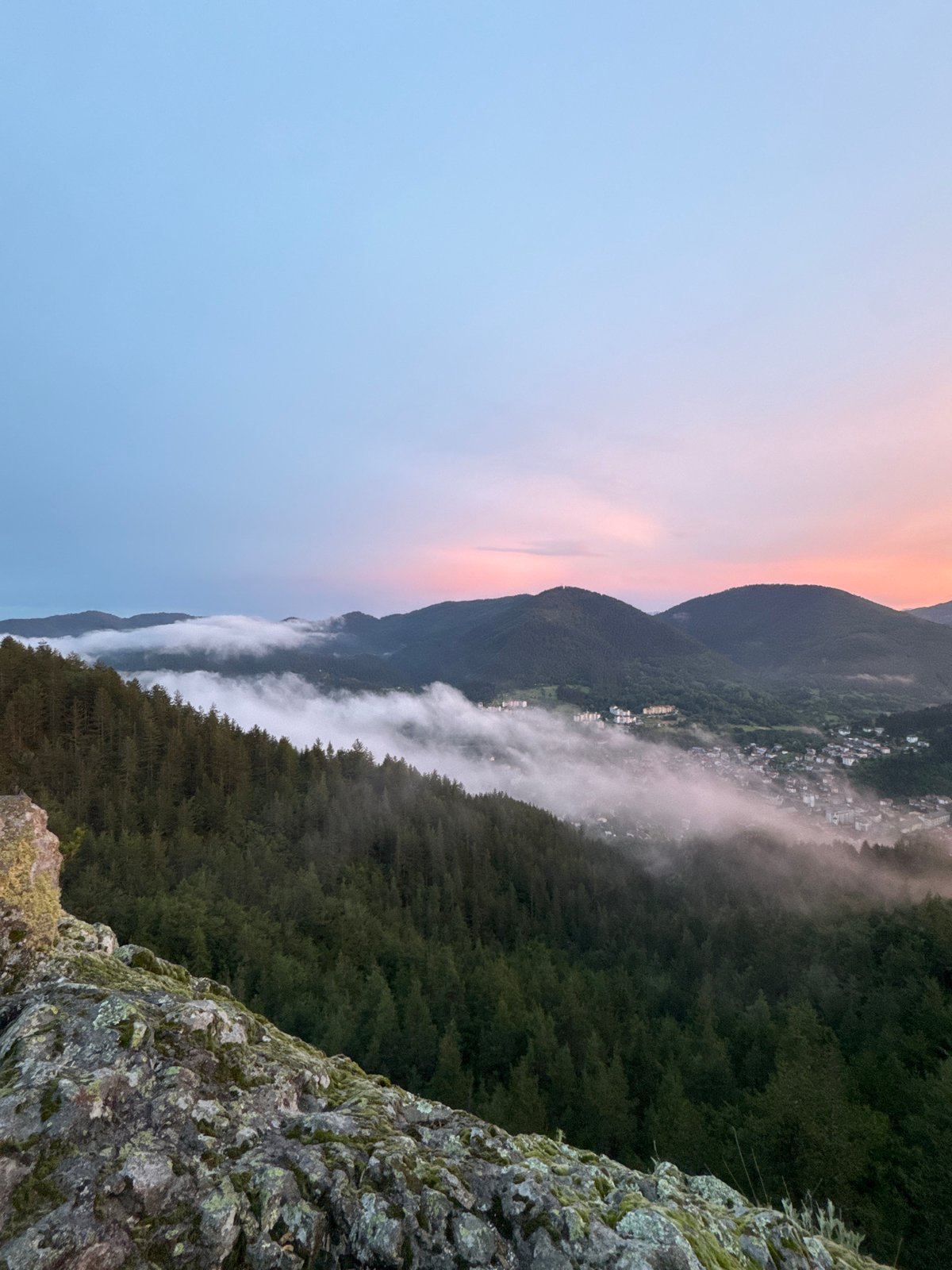 Sunset over Smolyan valley, framed by a hilltop metal cross