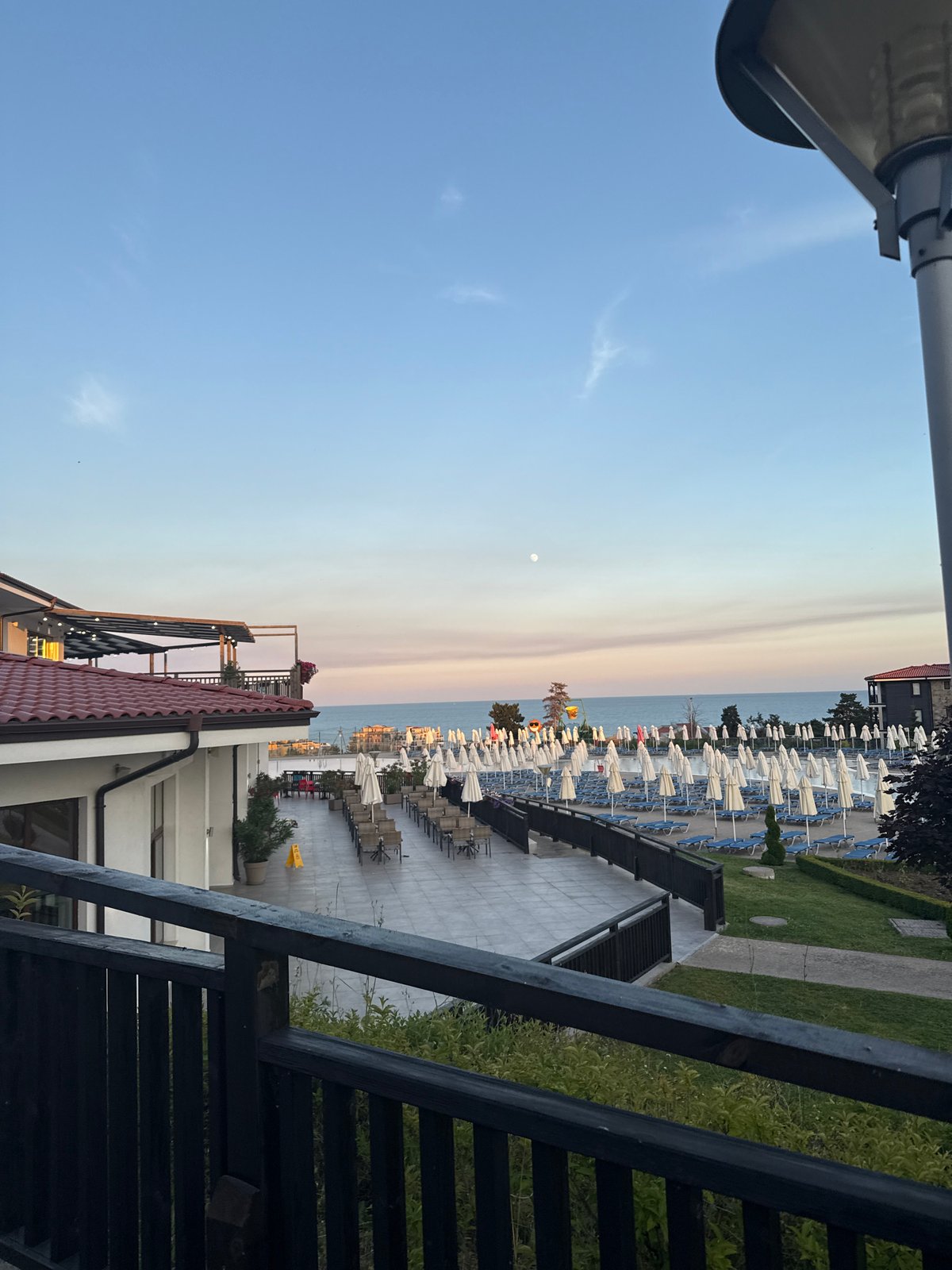 Resort terrace at dusk, framed by a wooden railing