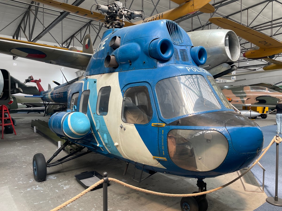 Inside a military aviation museum with aircraft, drones, and artillery
