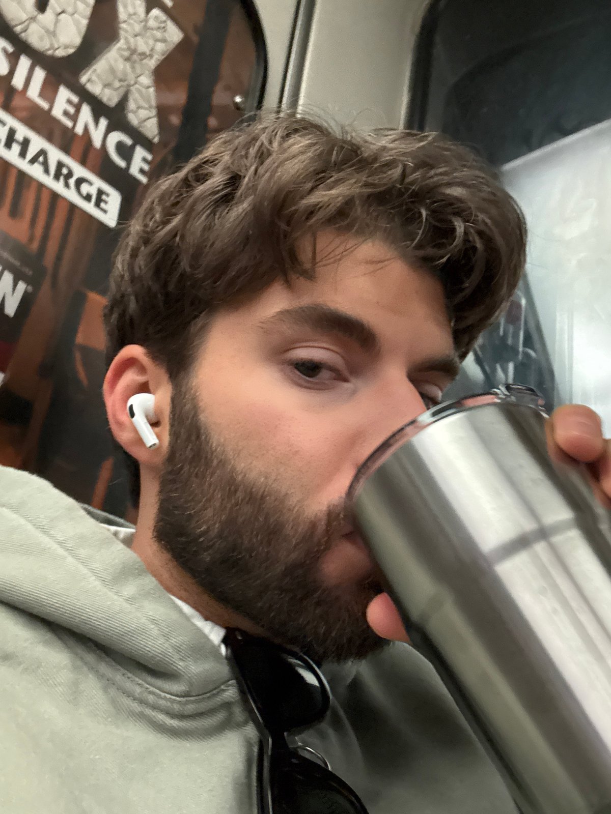 Man drinks from travel mug on Montreal public transit