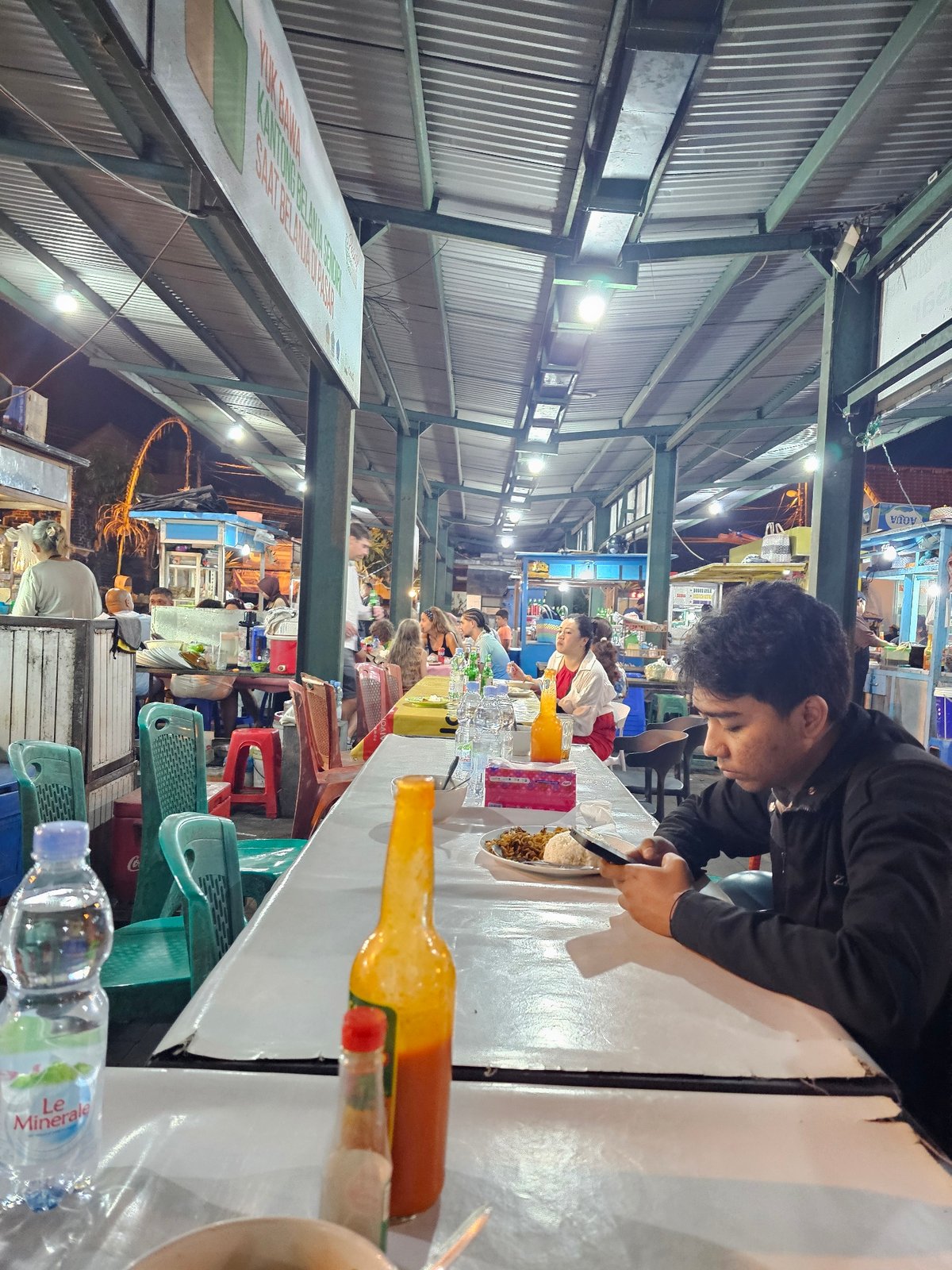 Late-night street food stall scene in Denpasar, Indonesia