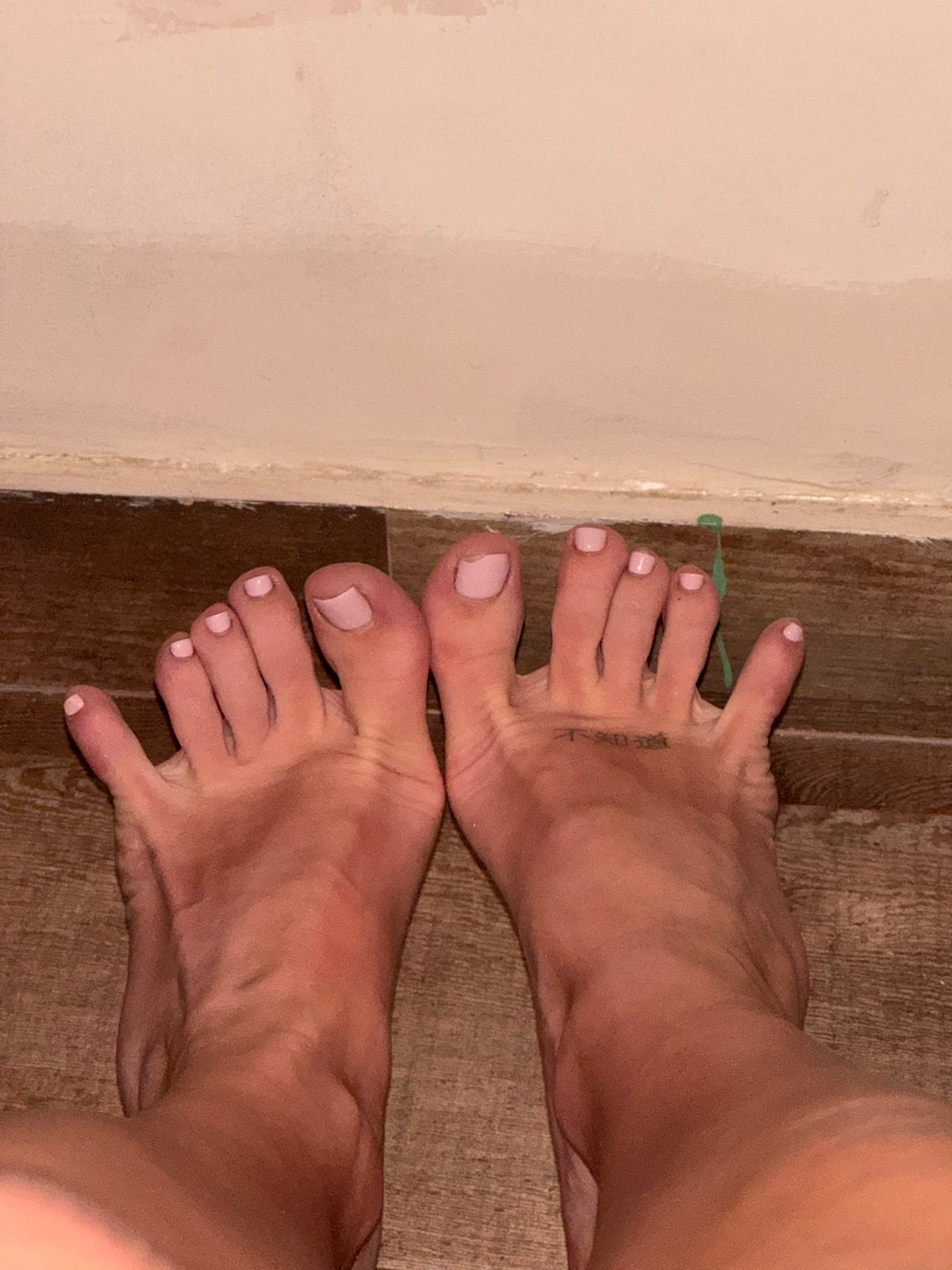 Person with tattooed foot observed near wall in Tibubeneng