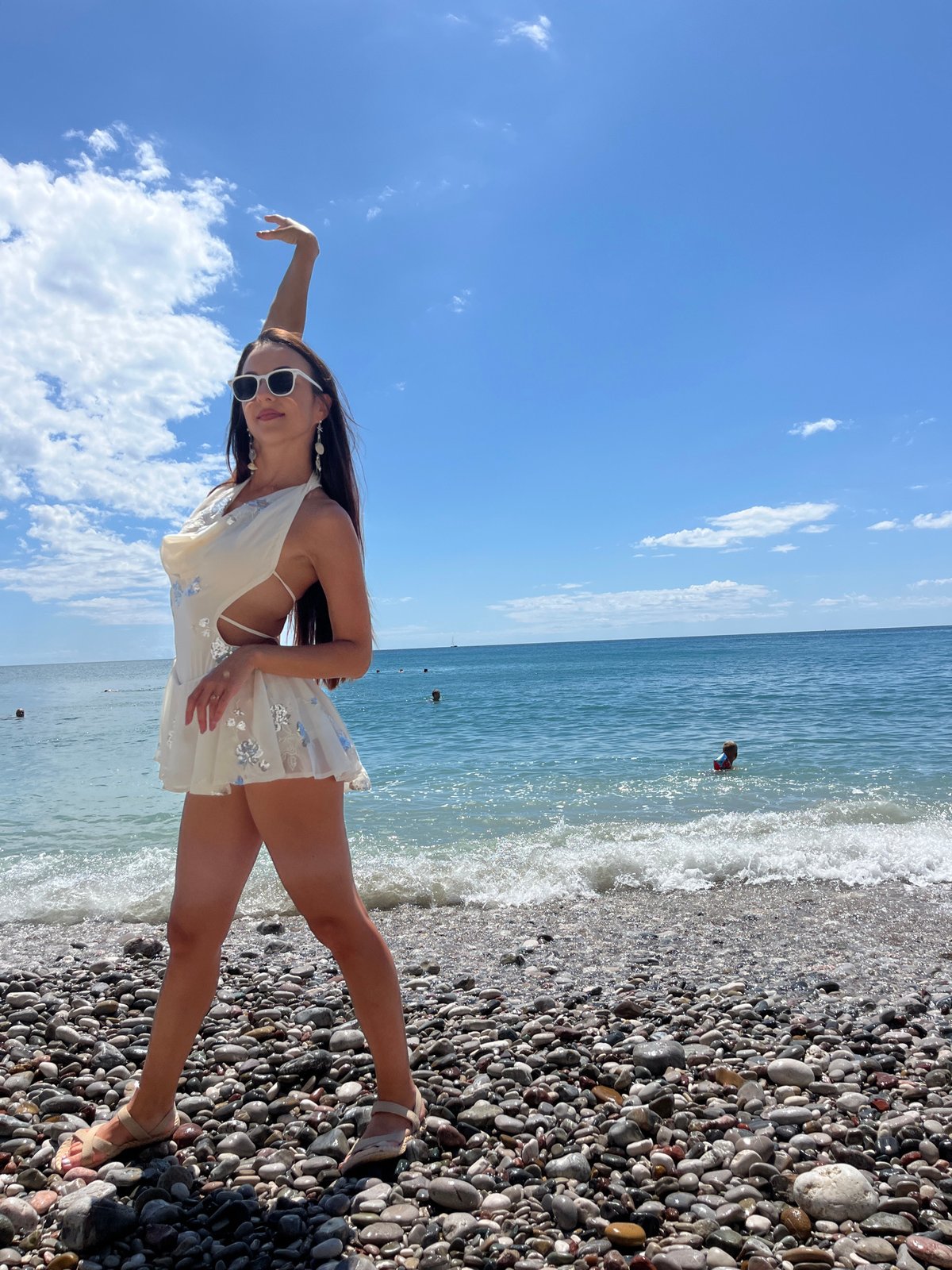 Woman poses for photos at Montenegro beach during summer afternoon