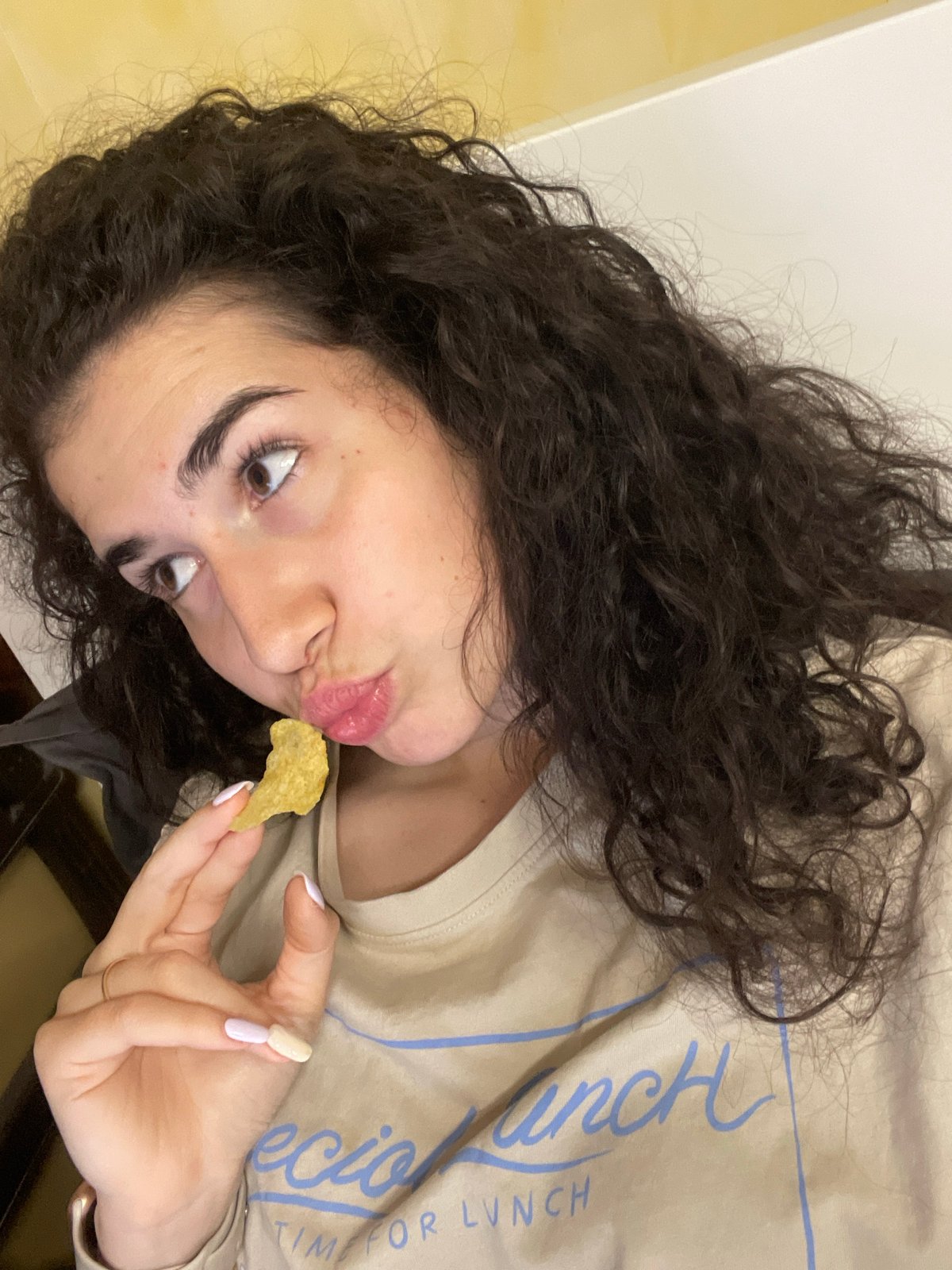 Evening routine: woman snacking, feeding excited poodle in Sofia