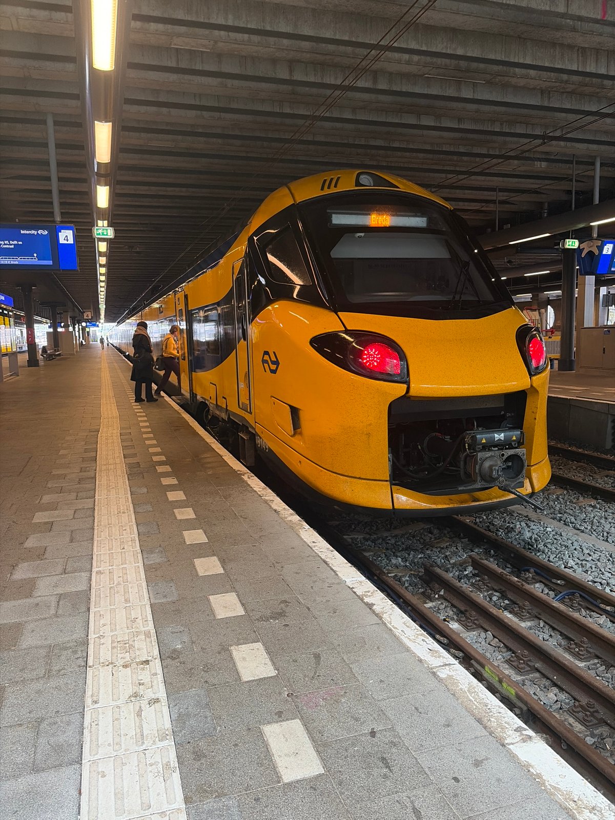 Dutch Railways train stops at modern terminal station